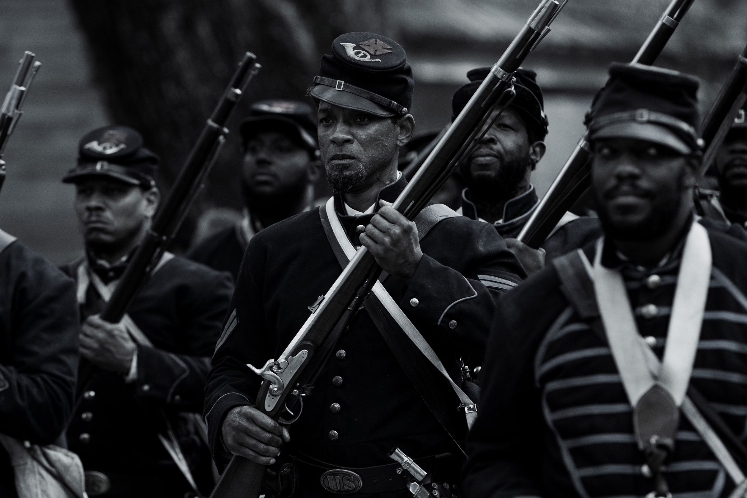 A black and white image of Black Union soldiers in their uniforms as they march to battle during the Civil War.