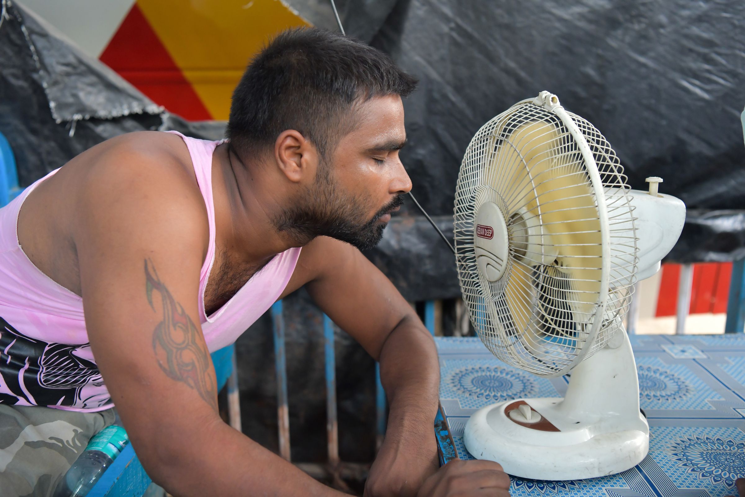 A man is seen taking a break from work cooling himself down...