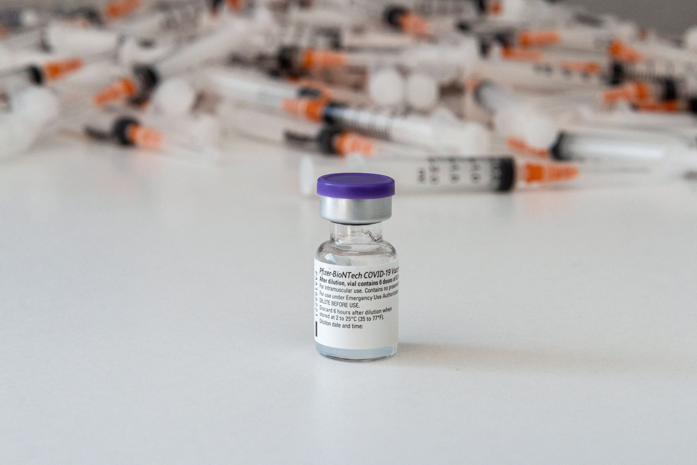 Biontech vaccine vial is seen infornt of syringes during a...