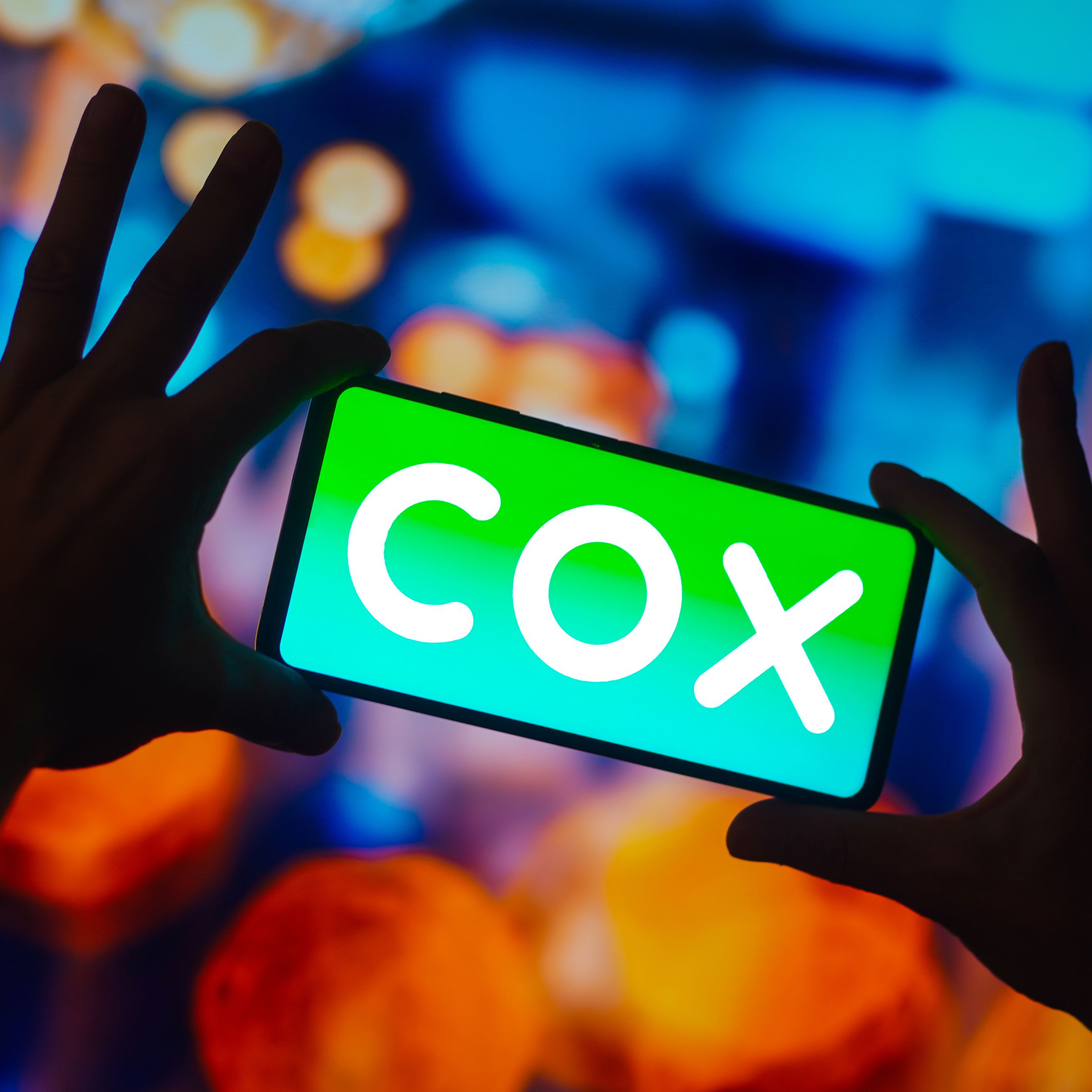 In this photo illustration, the Cox Communications logo is...