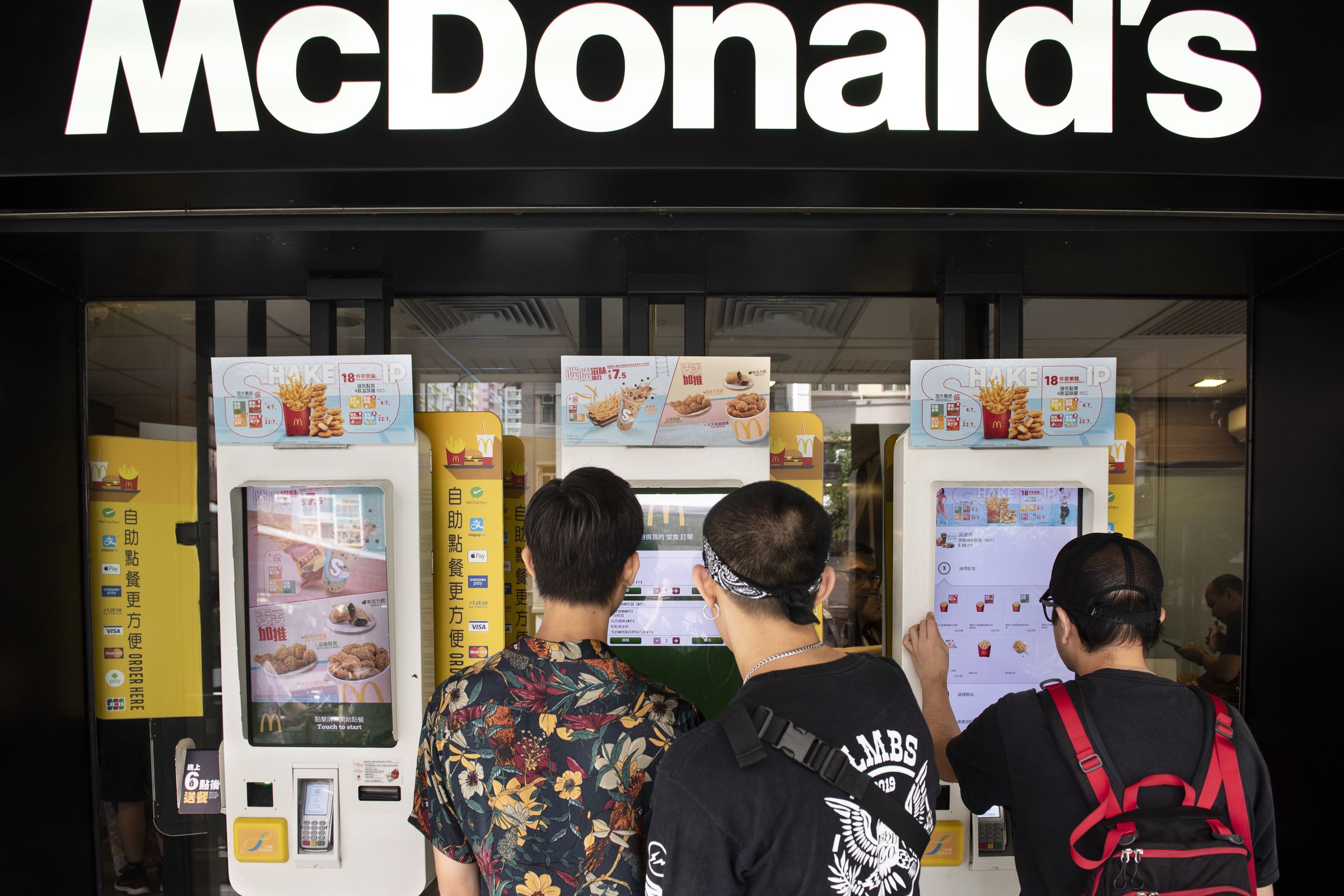 Customers order food in an automated self-ordering kiosk at...