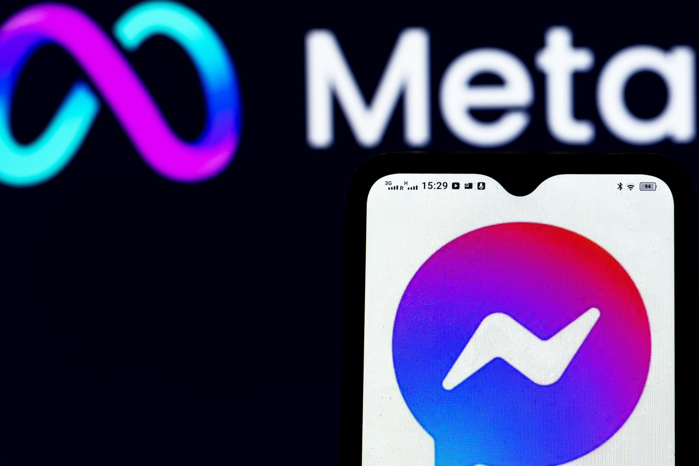 In this photo illustration a Facebook Messenger logo seen displayed on a smartphone and Meta Platforms logo in the background