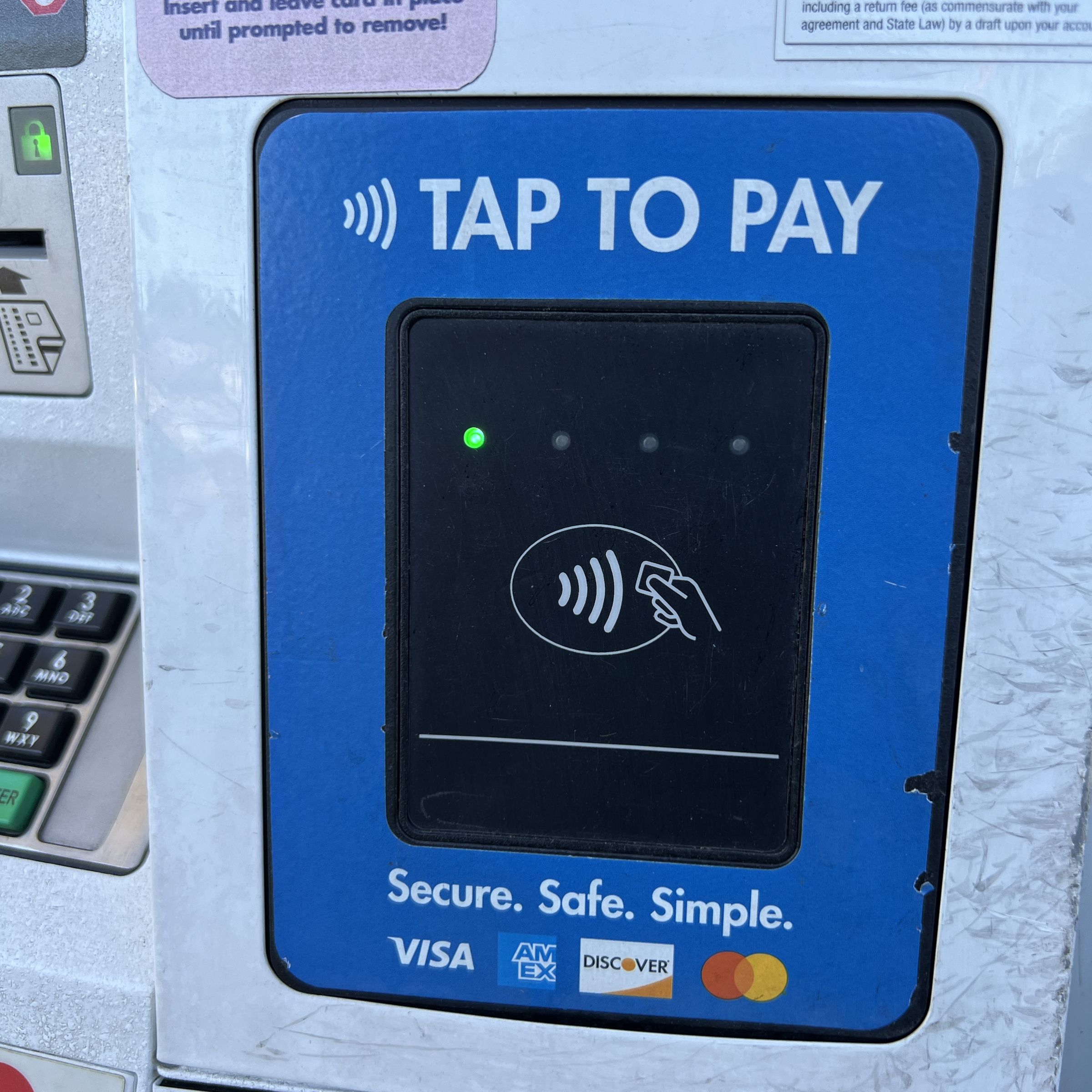 Credit card reader with a message stating Tap to Pay and logos for various payment cards on a gas pump in Lafayette, California, May 9th, 2024.