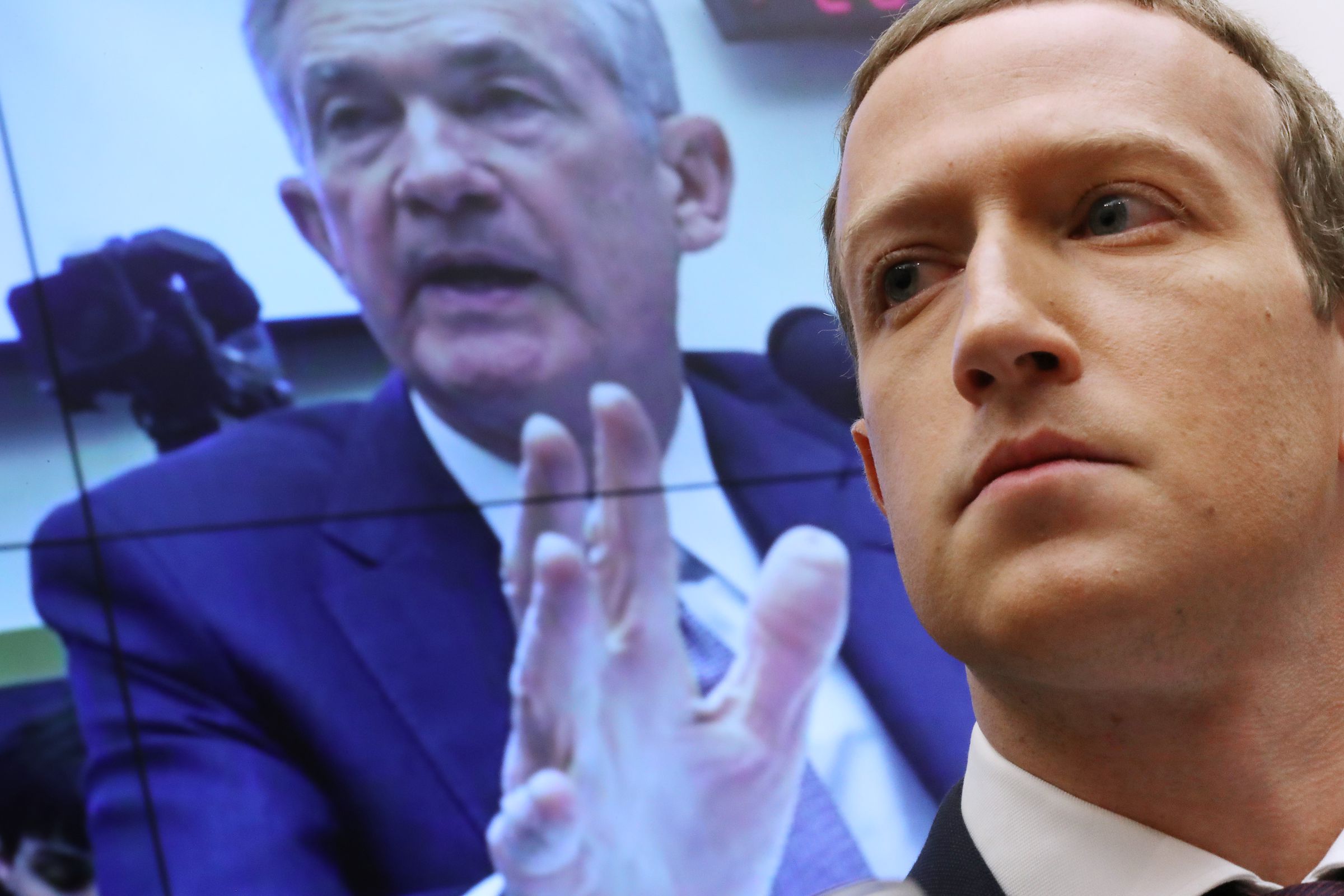 With an image of Federal Reserve Bank Chairman Jerome Powell on a screen in the background, Facebook co-founder and CEO Mark Zuckerberg testifies before the House Financial Services Committee in the Rayburn House Office Building on Capitol Hill October 23, 2019 in Washington, DC.