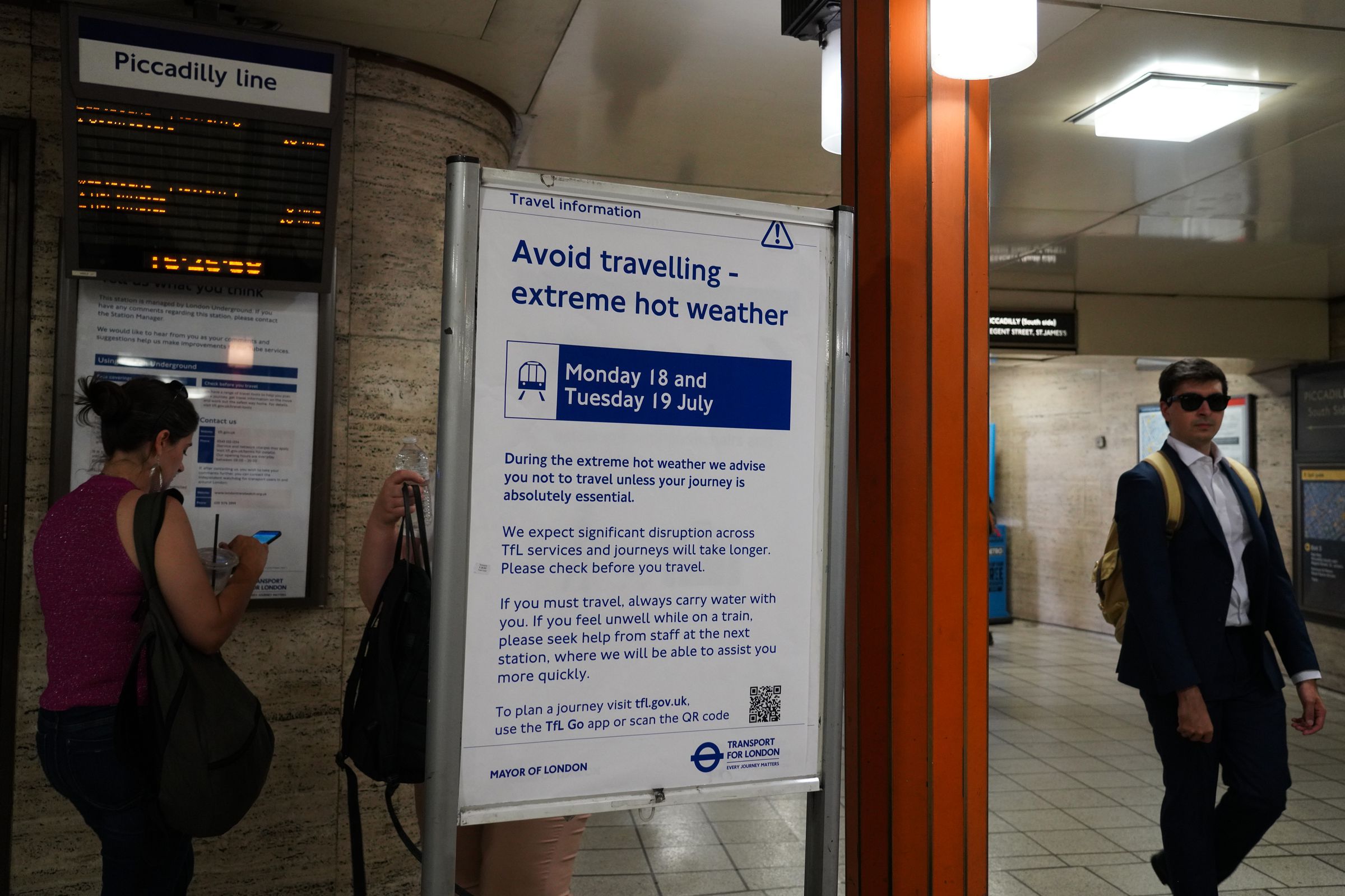A sign in a subway station says “Avoid traveling — extreme hot weather”