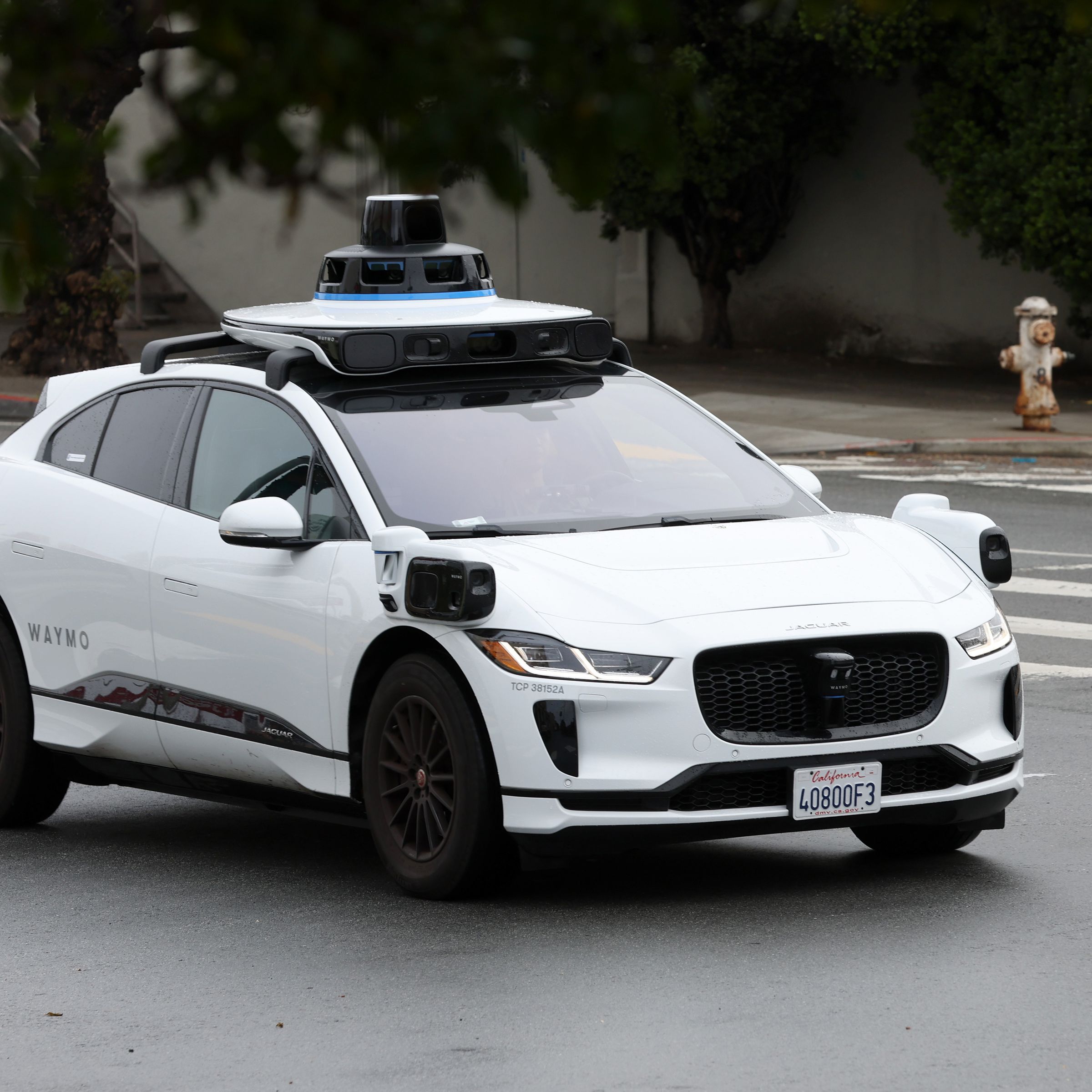 A white Waymo vehicle on the road