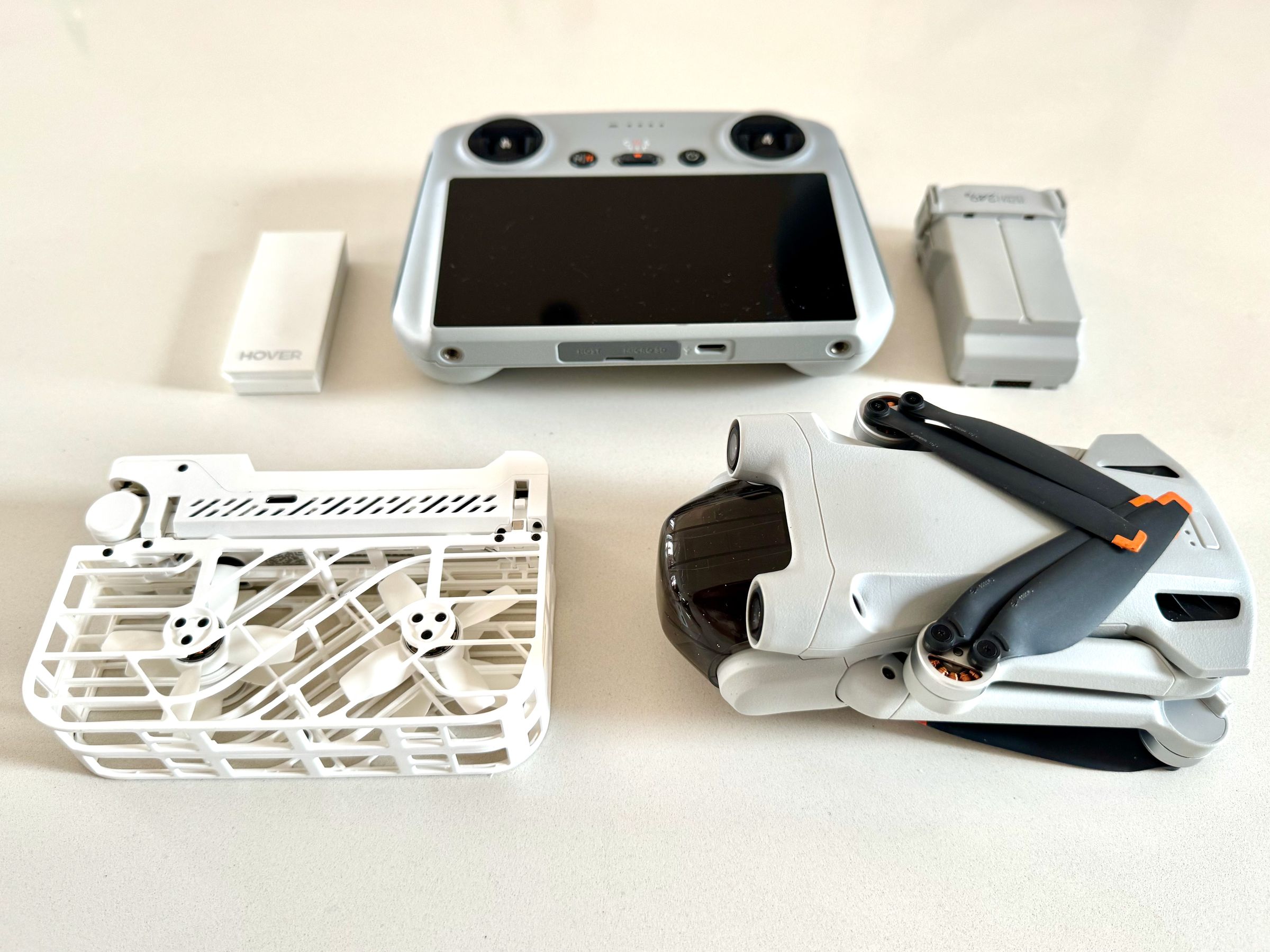 The collapsed HoverAir X1 and battery vs. DJI Mini 3 Pro, battery, and controller.