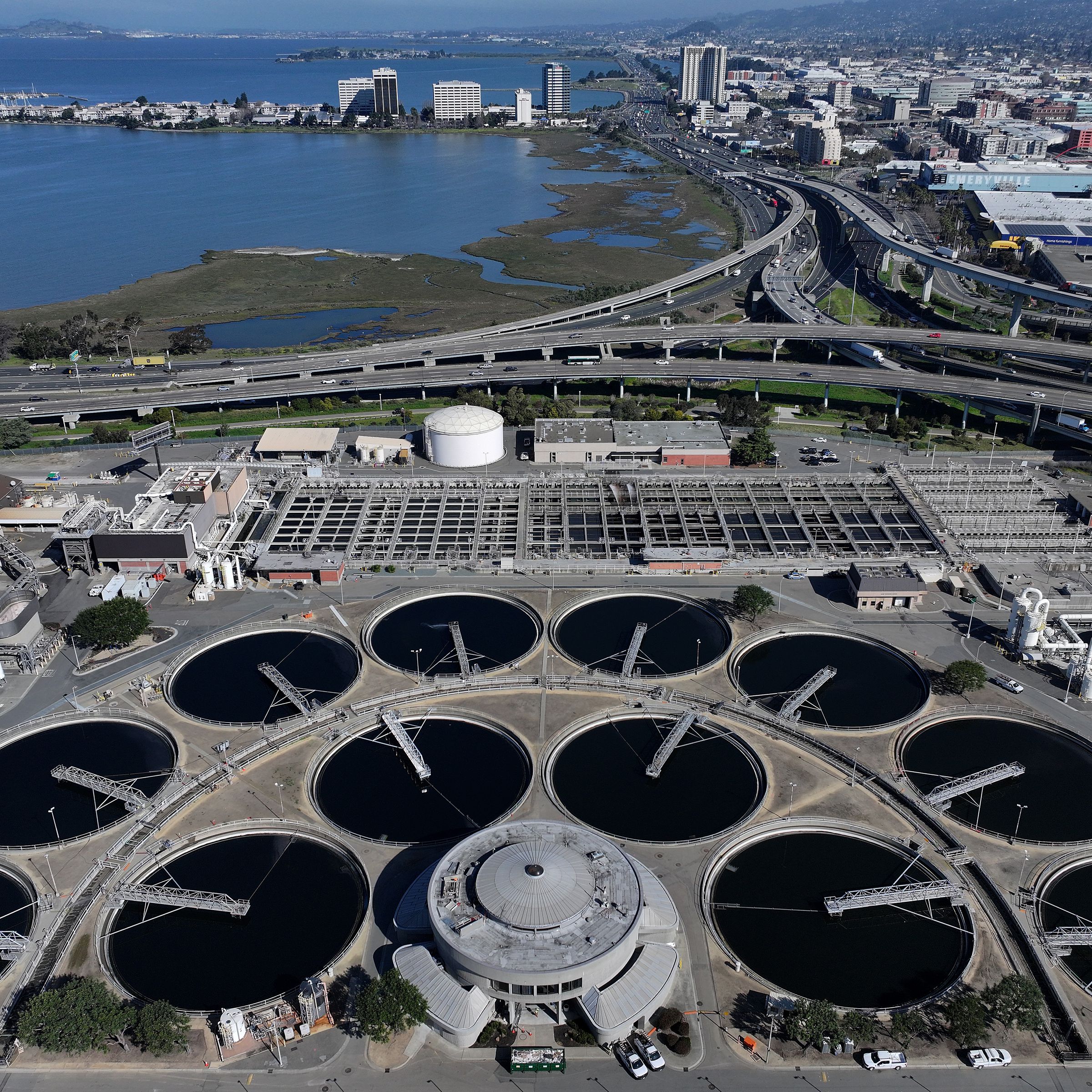 In an aerial view, pools of water lined up in two concentric semicircles are visible at the East Bay Municipal Utility District Wastewater Treatment Plant on March 20th, 2024, in Oakland, California.&nbsp;