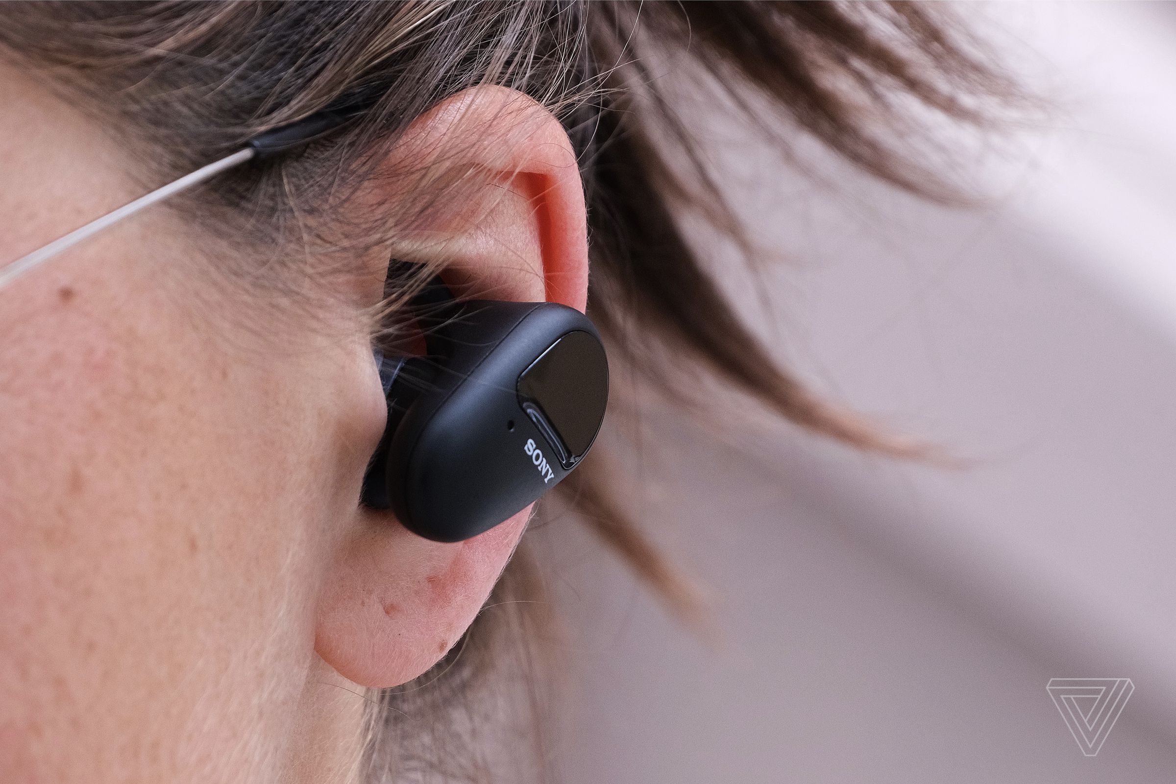 A close-up image of a Sony’s SP-800N earbuds in someone’s ear.