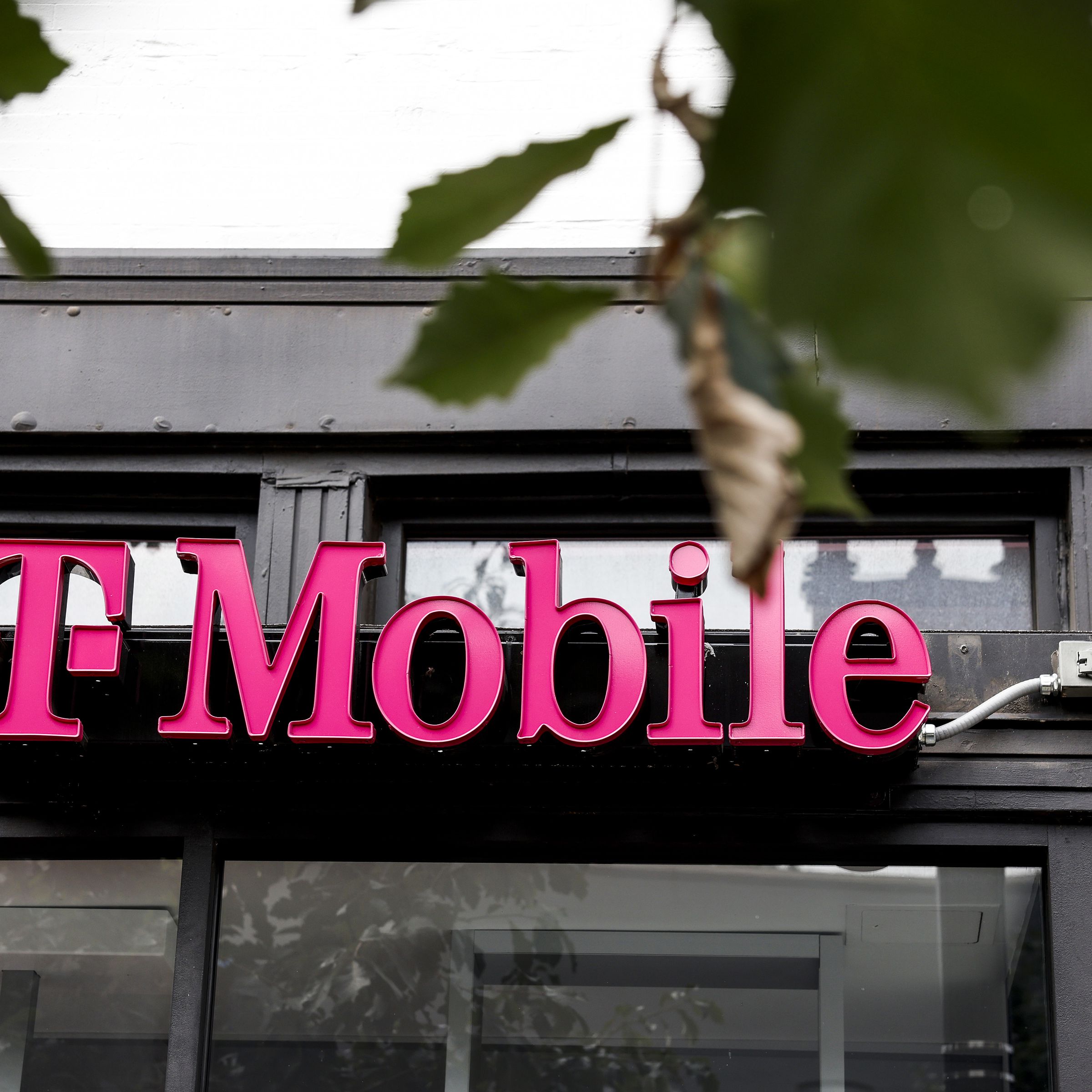 Signage for T-Mobile hangs on a storefront