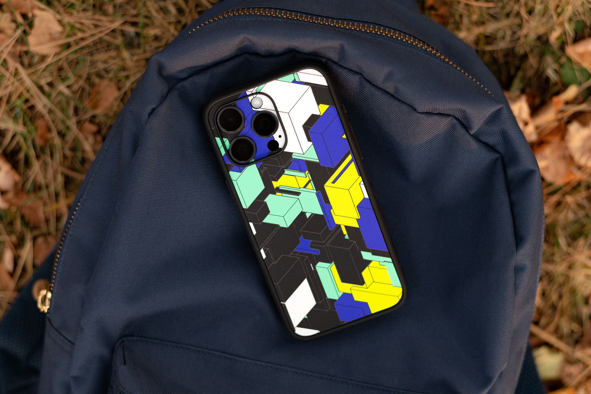 The Verge’s Blocks skin with a dbrand Grip case on an iPhone sitting on a backpack outside