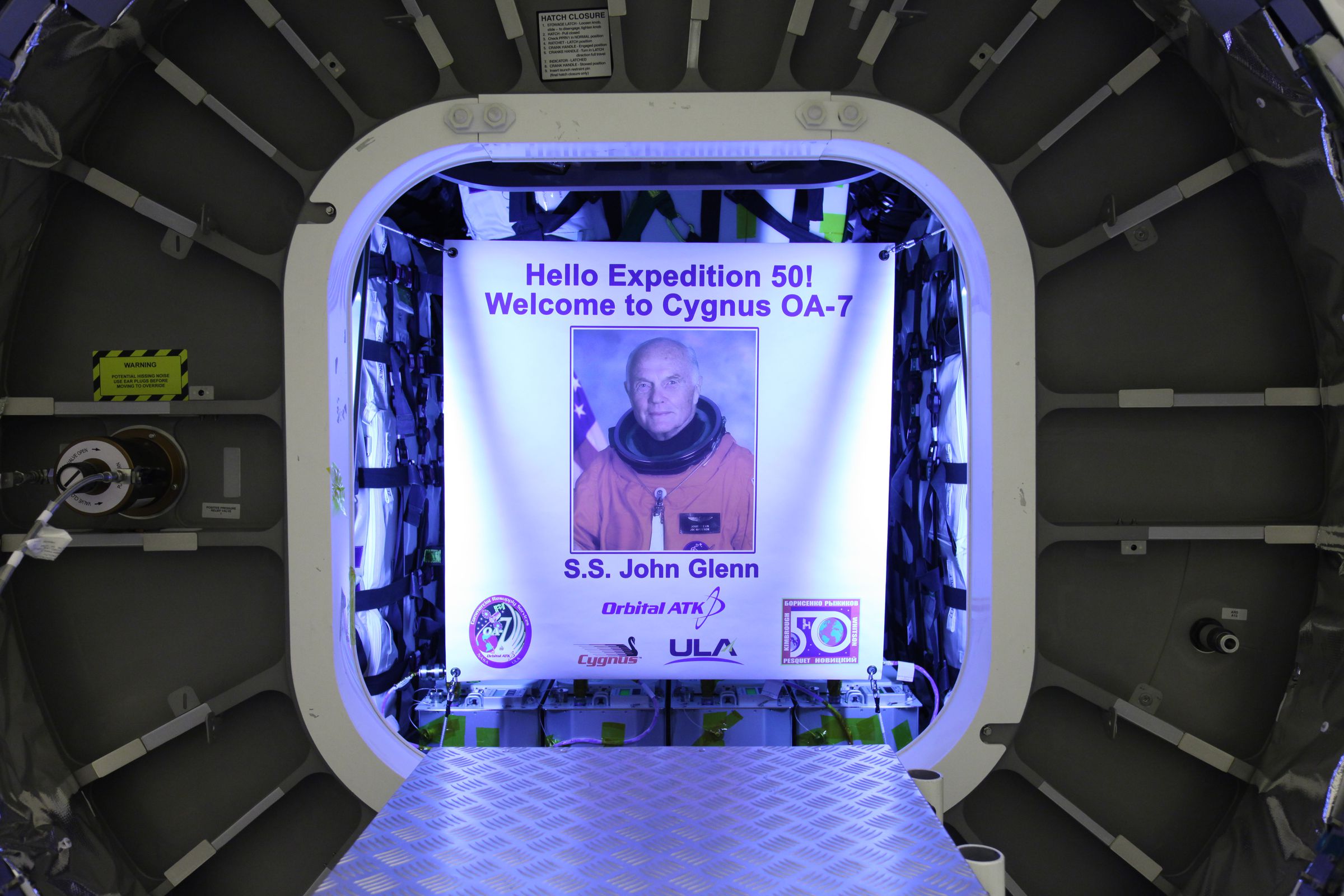 A banner with John Glenn’s portrait hangs inside the Cygnus.