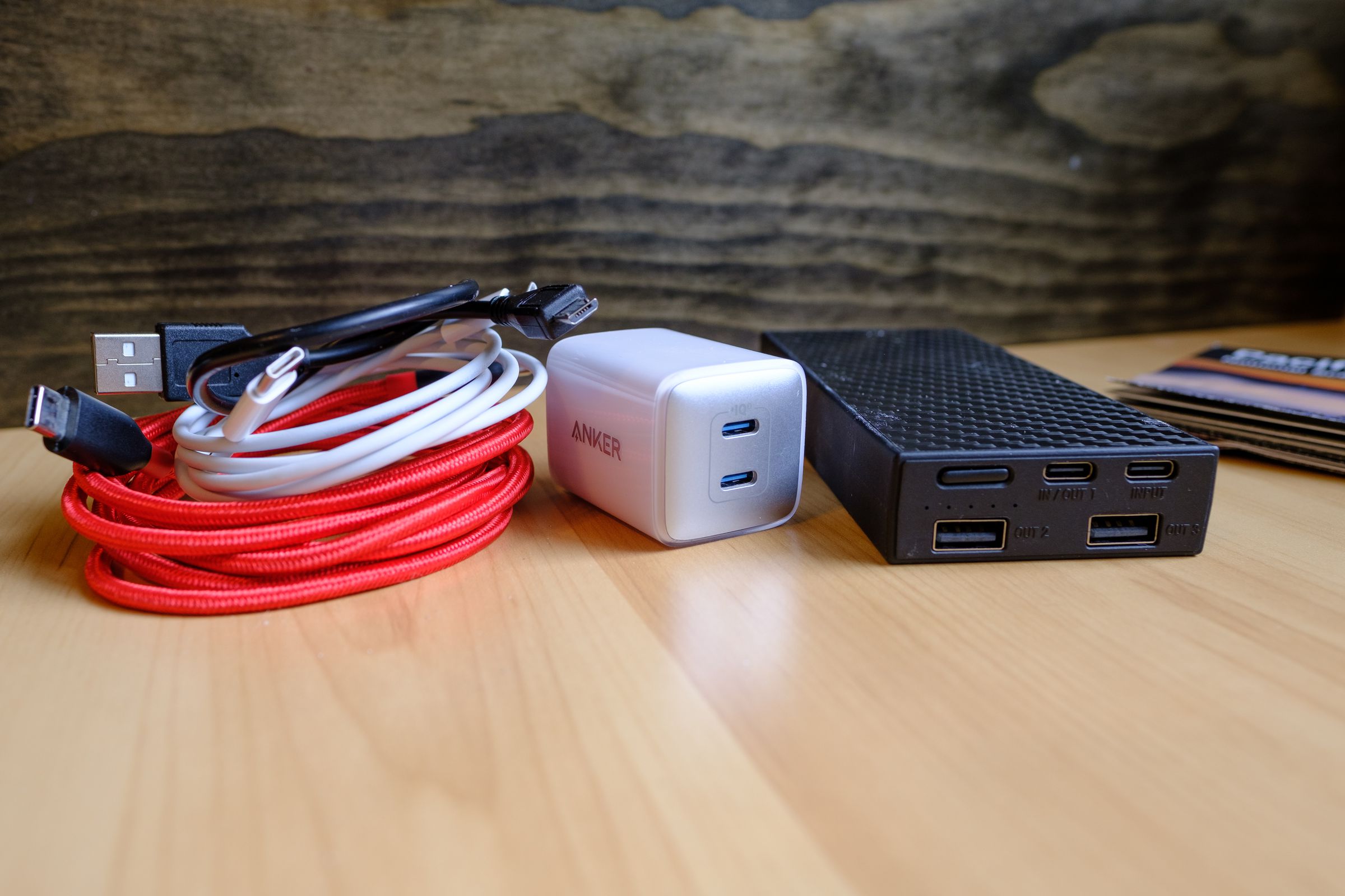 Photo of three cables, a charging brick, and a powerbank.