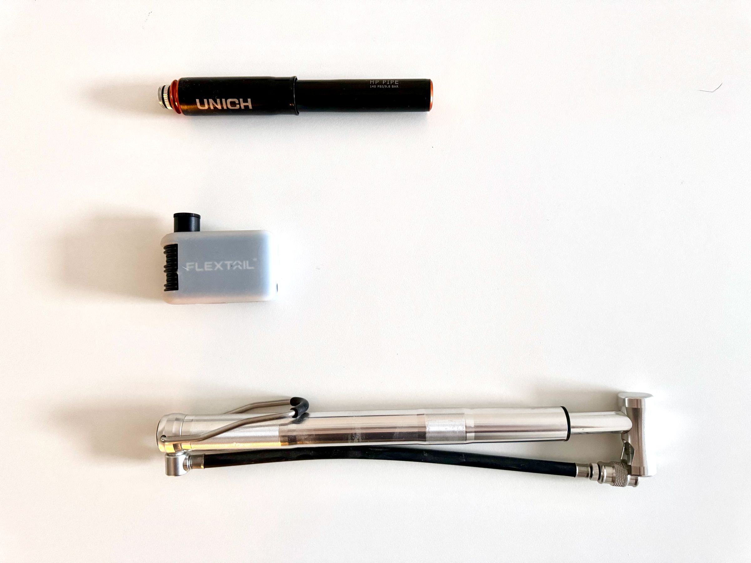 <em>The Flextail compared to two mini pumps, my trusty Unich pump (top) and a mini standing pump from Pro Bike Tool (bottom).</em>