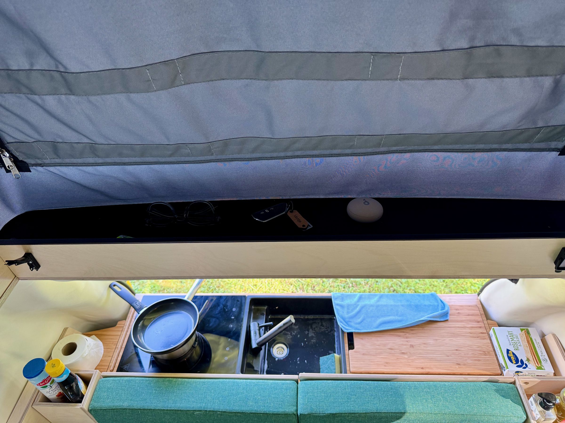 <em>A view of the kitchen from the pop-top bed, where there’s nearby access to USB jacks, light switches, and a padded ledge to store glasses and anything else you might need at night.</em>