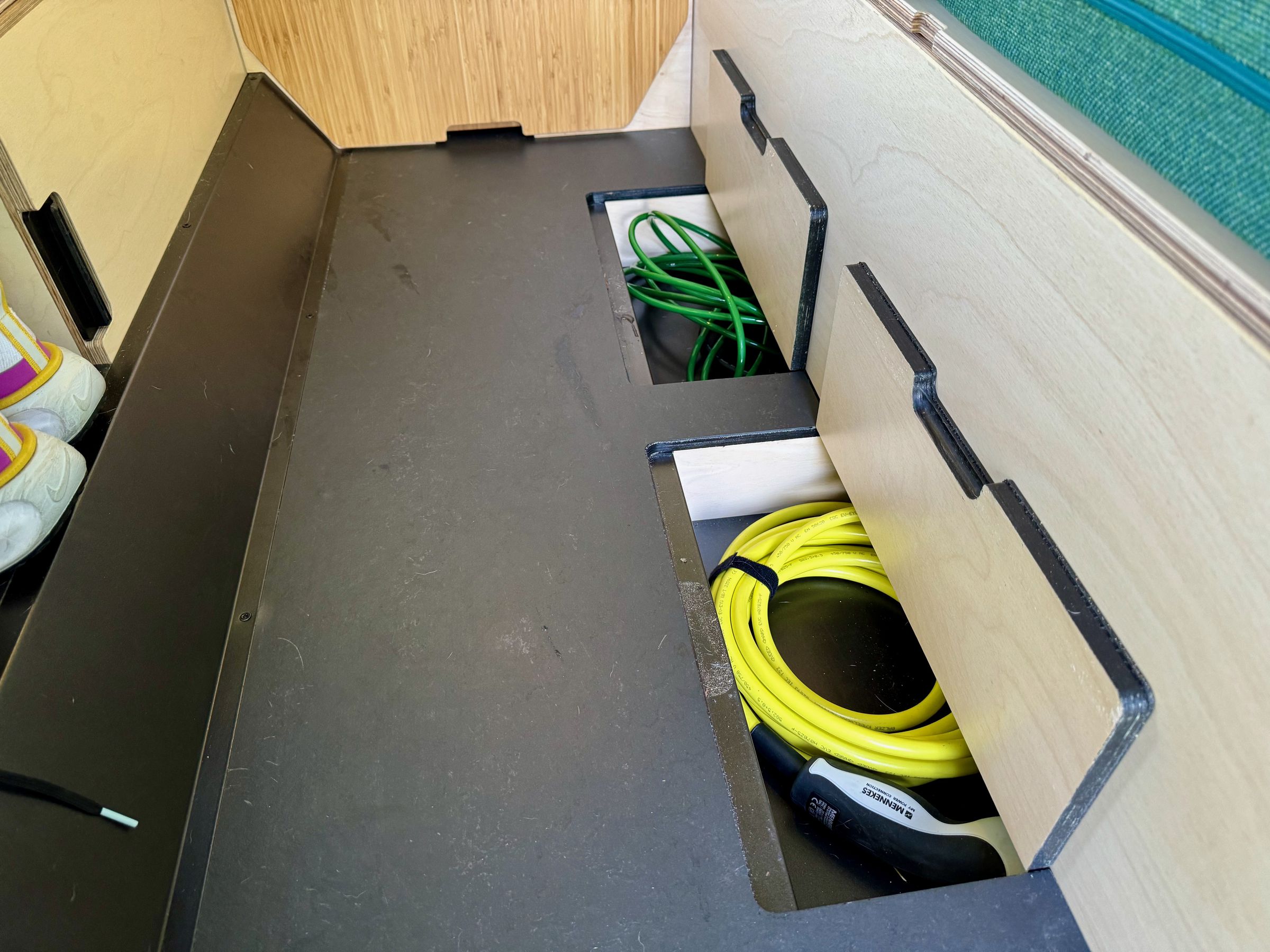 <em>Underfloor storage for charging cables.</em>