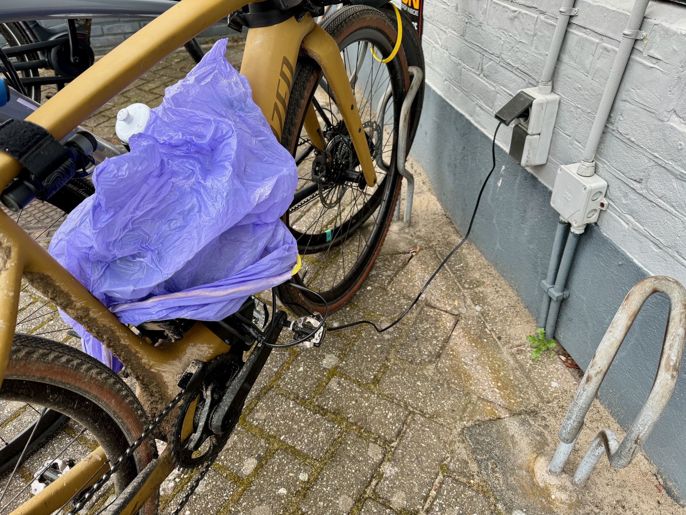 <em>Another cafe offering free e-bike charging to customers. It was raining so I had to use a trash bag to cover the charging brick and the charging points on the bike and range extender.</em>