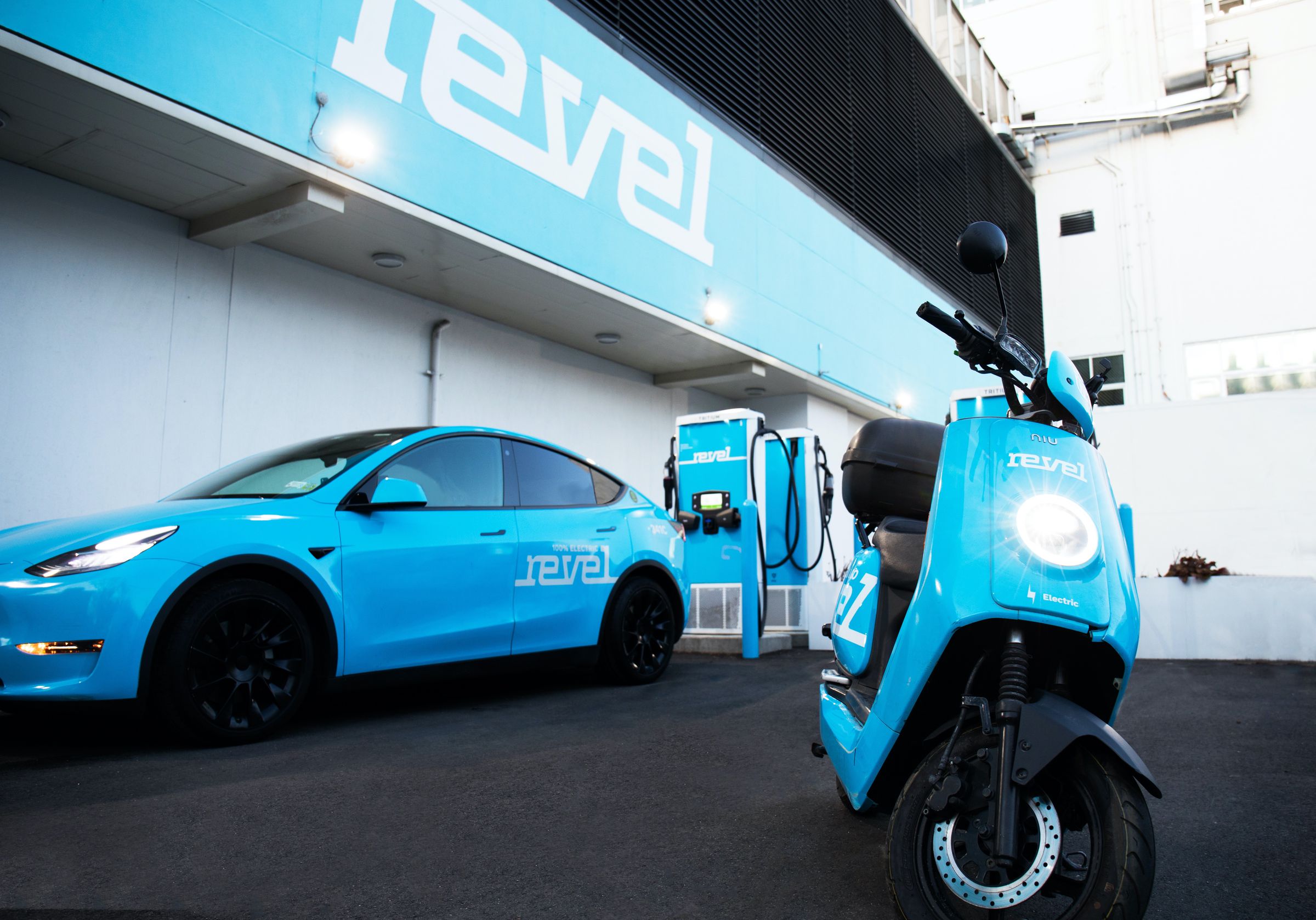 A picture of a Revel moped and Tesla EV and 