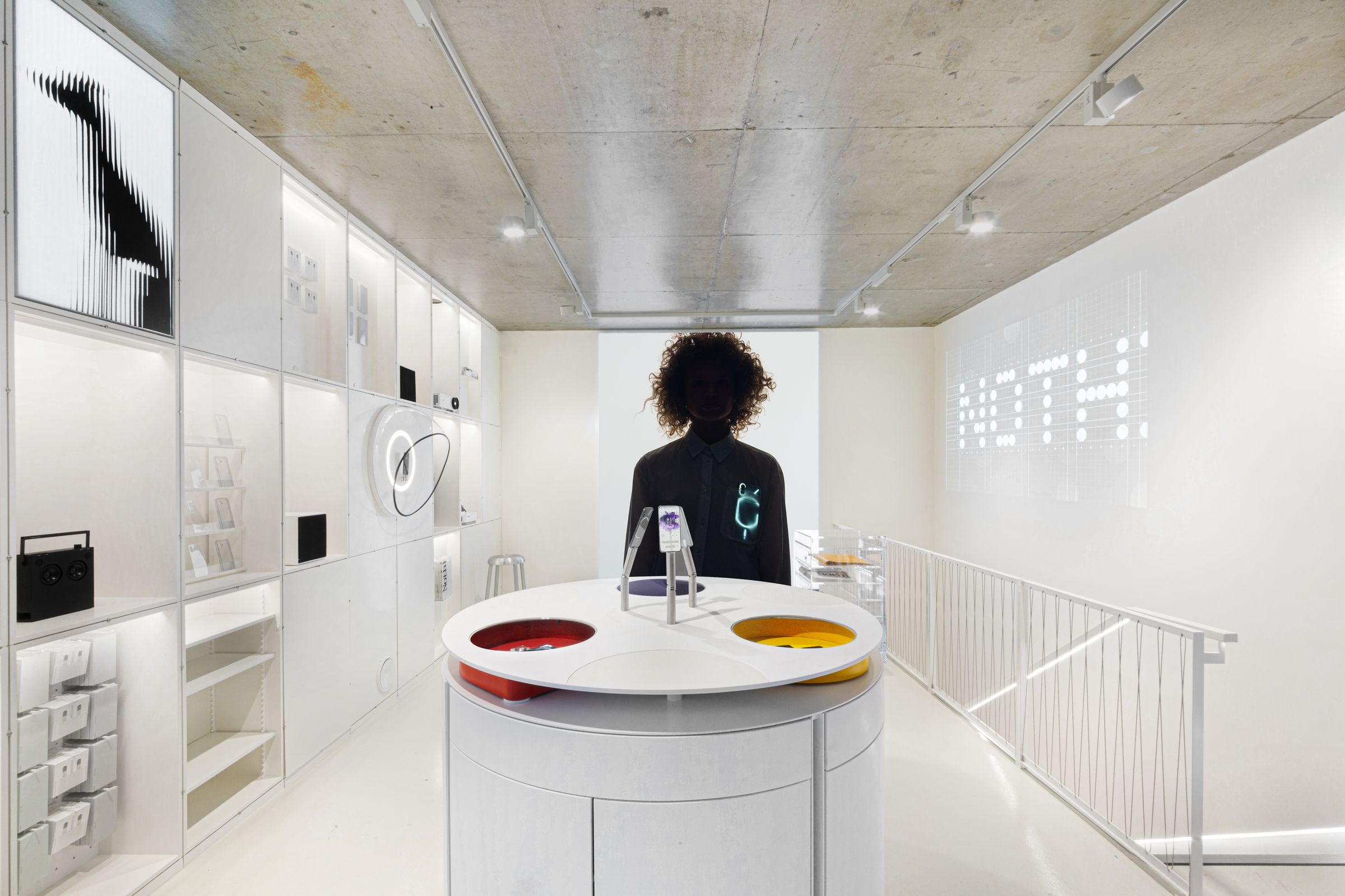 A photograph taken within the Nothing Store in London, Soho. The decor is white and minimalistic, with transparent embellishments.