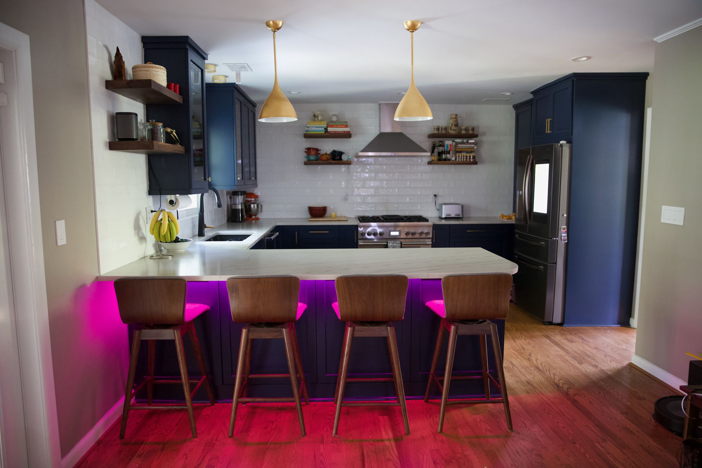 A kitchen and dining area with chairs around a white-topped counter.