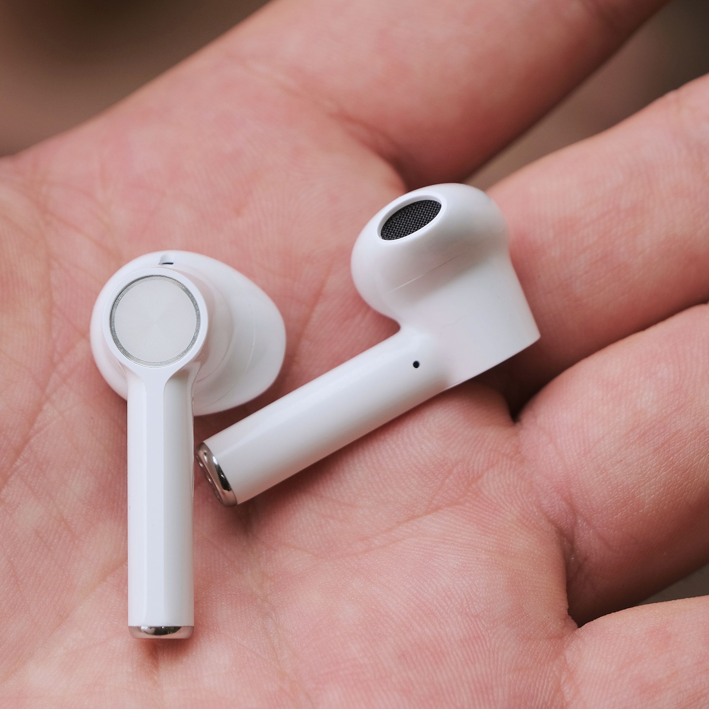 A close-up photo of the OnePlus earbuds in a person’s hand.
