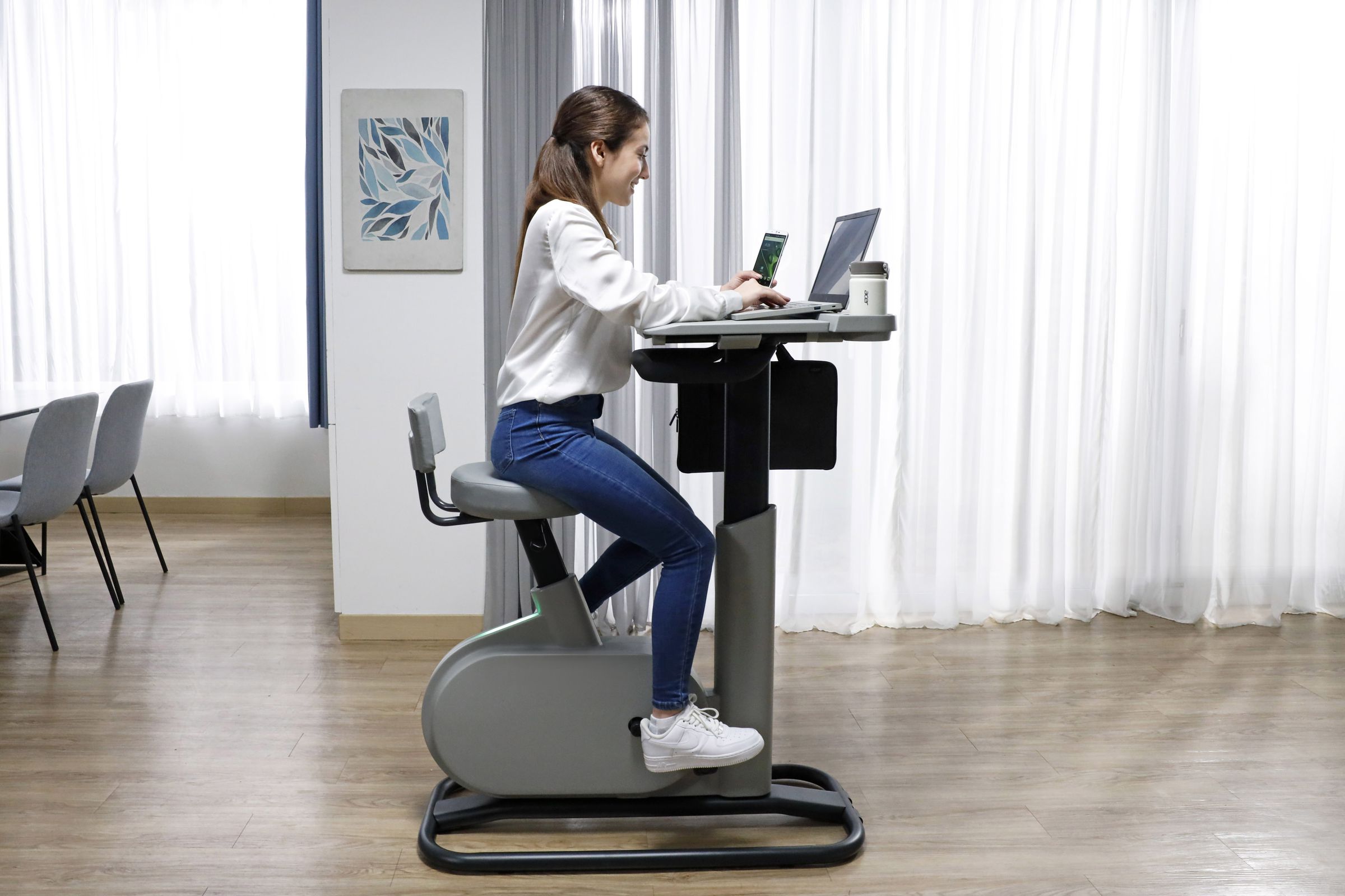 Acer’s eKinekt BD 3 bicycle meets desk is shown from the side, with a user working on it as they pedal.