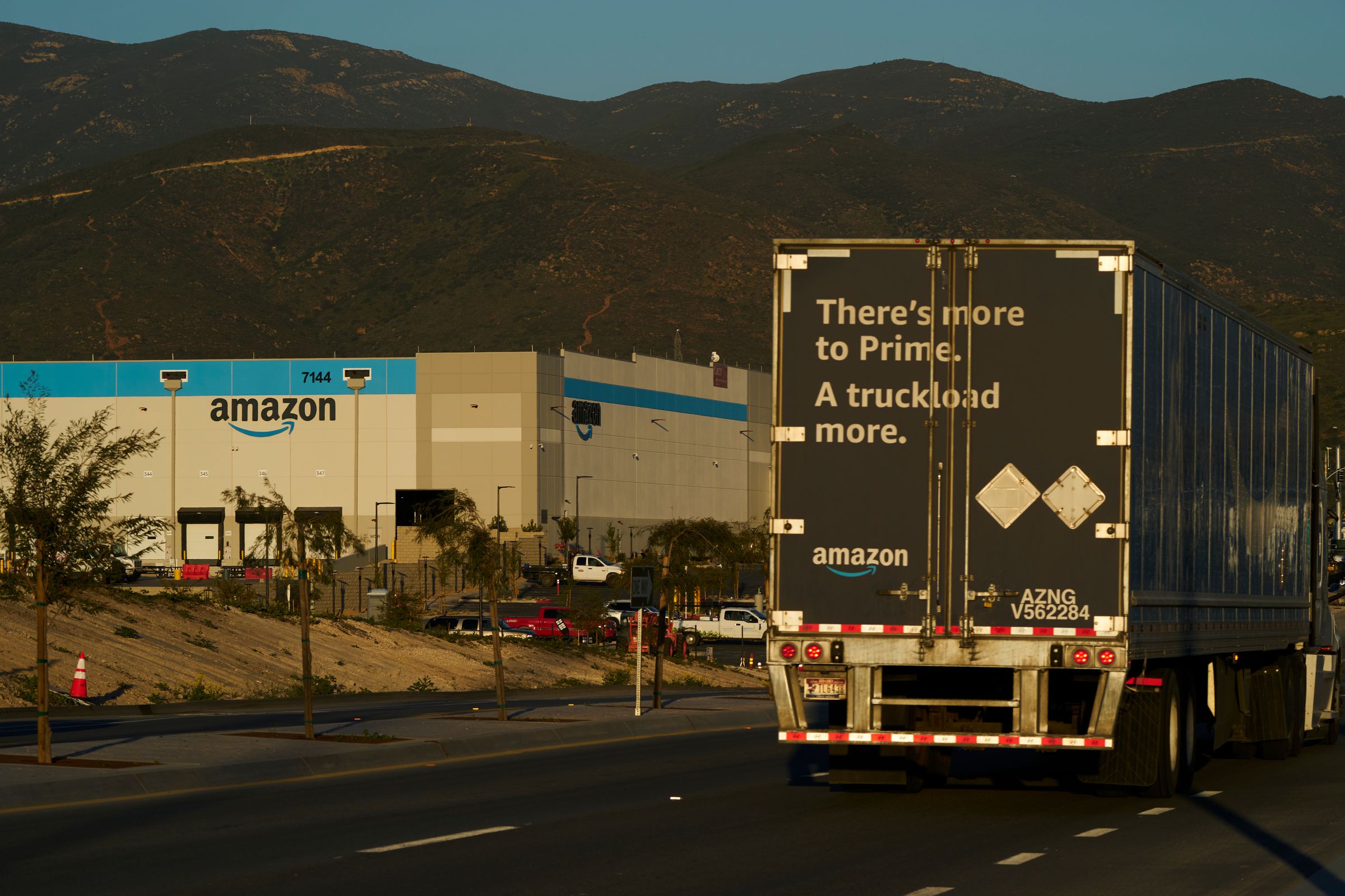 A semi truck drives past an Amazon sort center under construction in the Otay Mesa neighborhood of San Diego, California, US, on Wednesday, March 9, 2022.