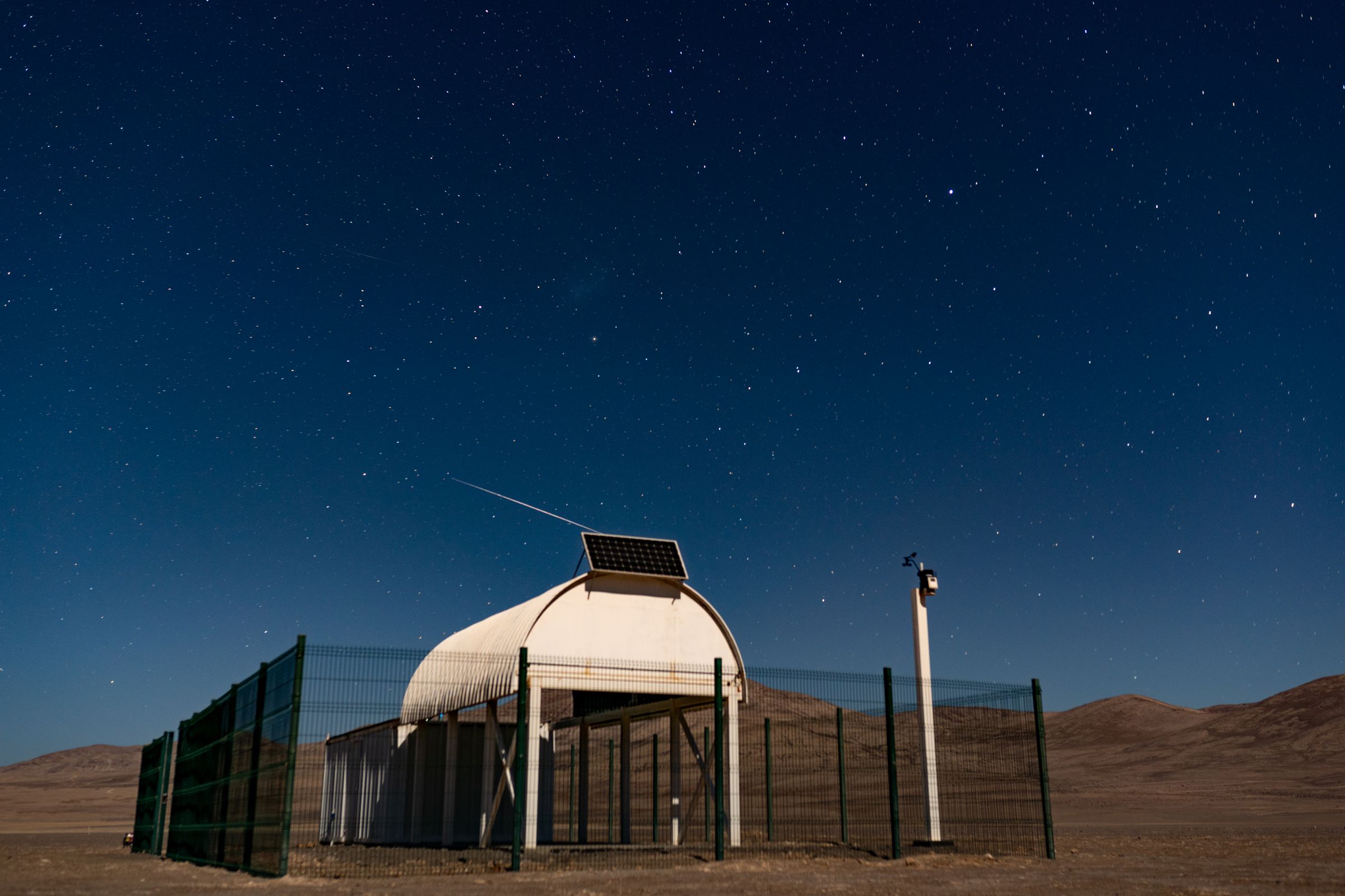 The Ckoirama Observatory in Chile, while a trail of Starlink satellites pass overhead.