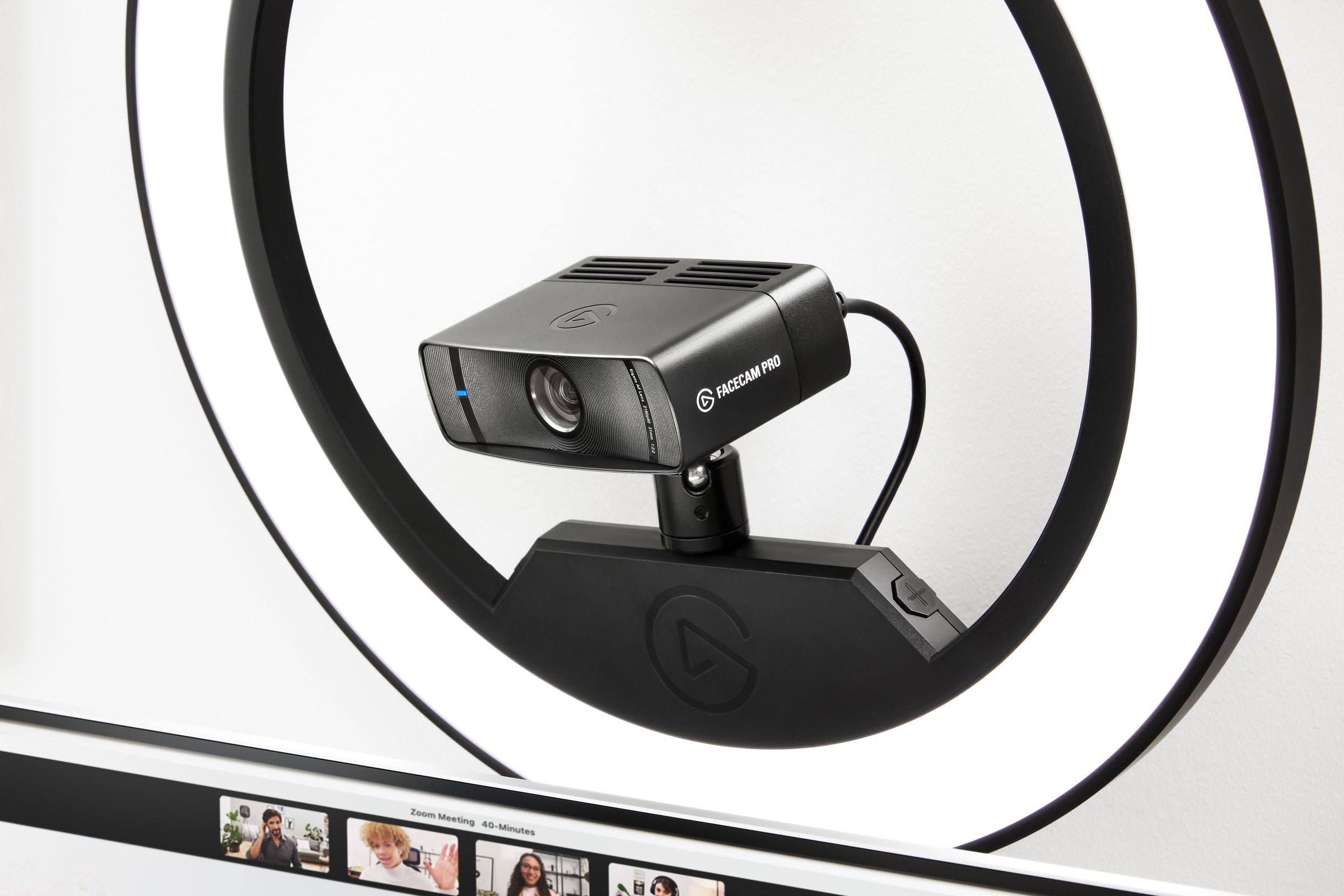 The Elgato Facecam Pro sits on top of a ring light mount, aimed at a user who is on a Zoom video call.