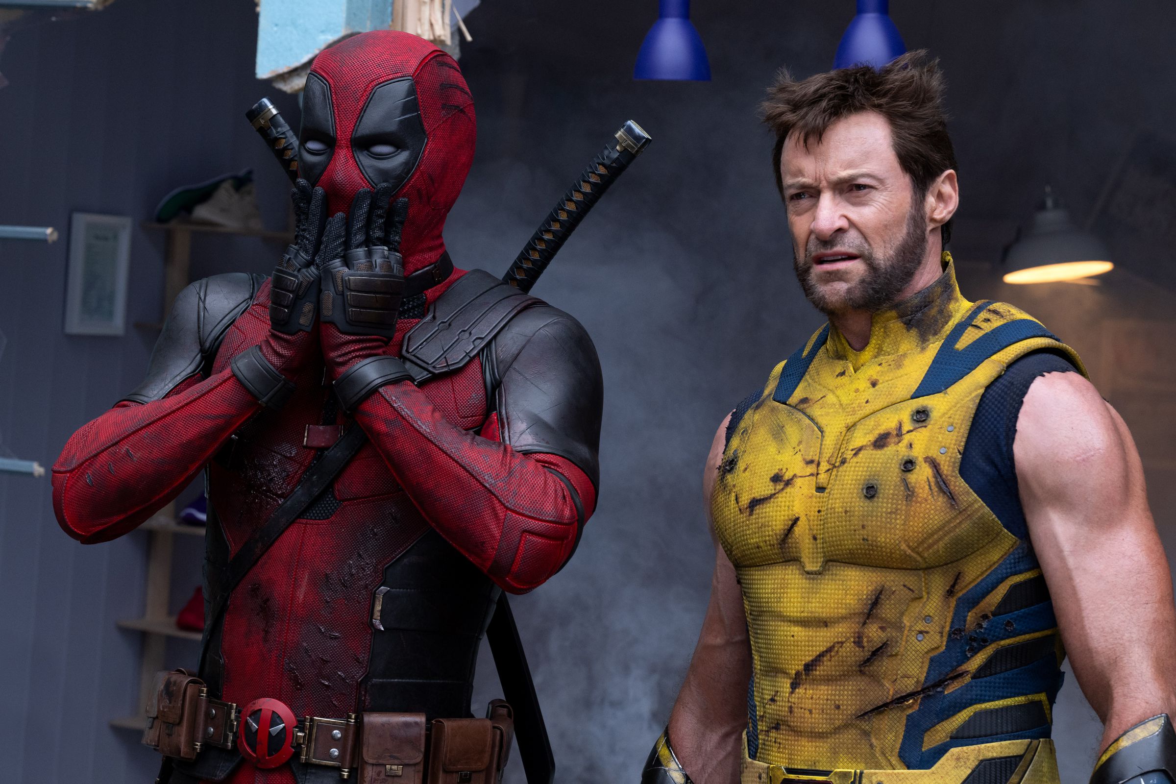 Deadpool and Wolverine standing together and looking at something with surprise on their faces.