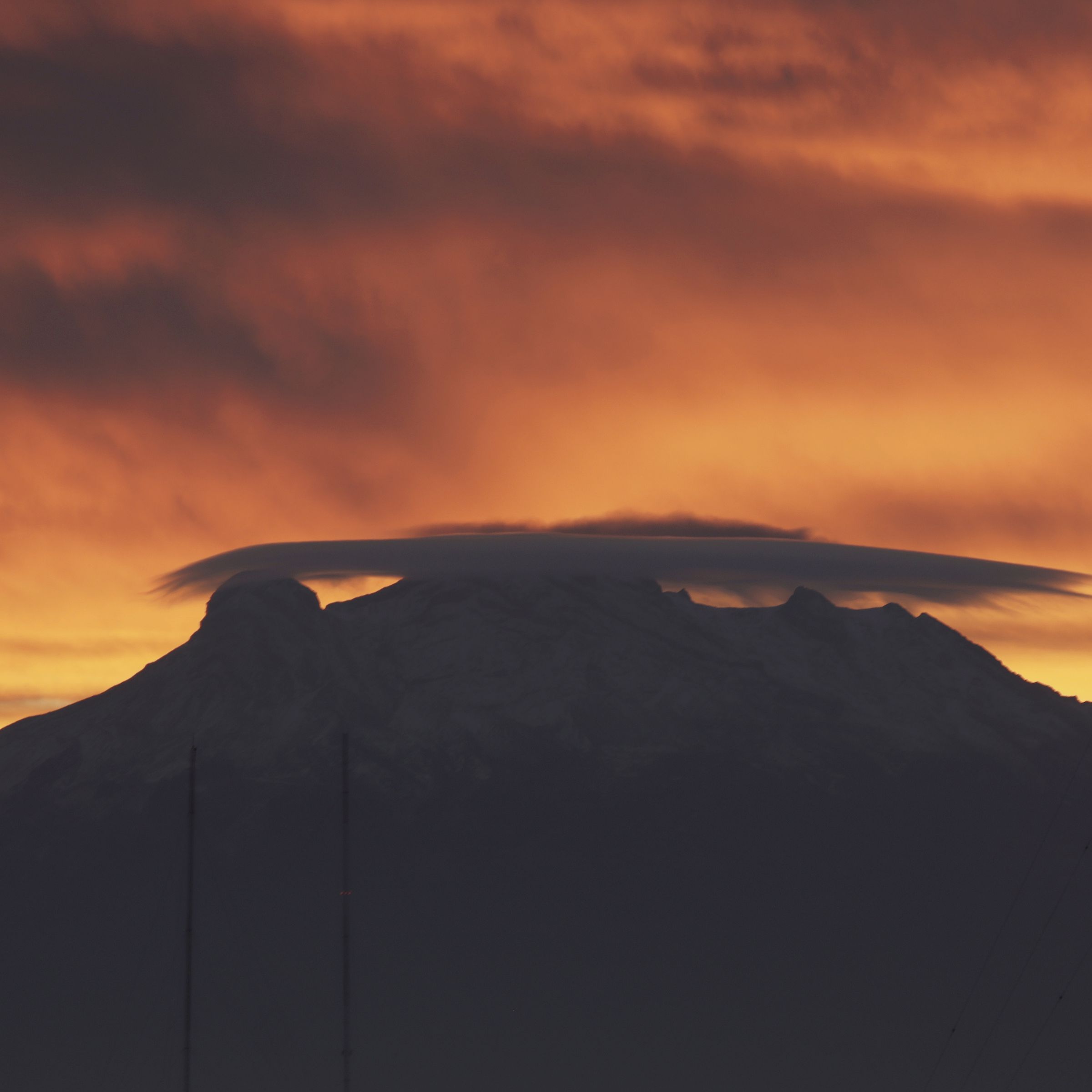 Clouds over a volcano during a bright orange sunrise