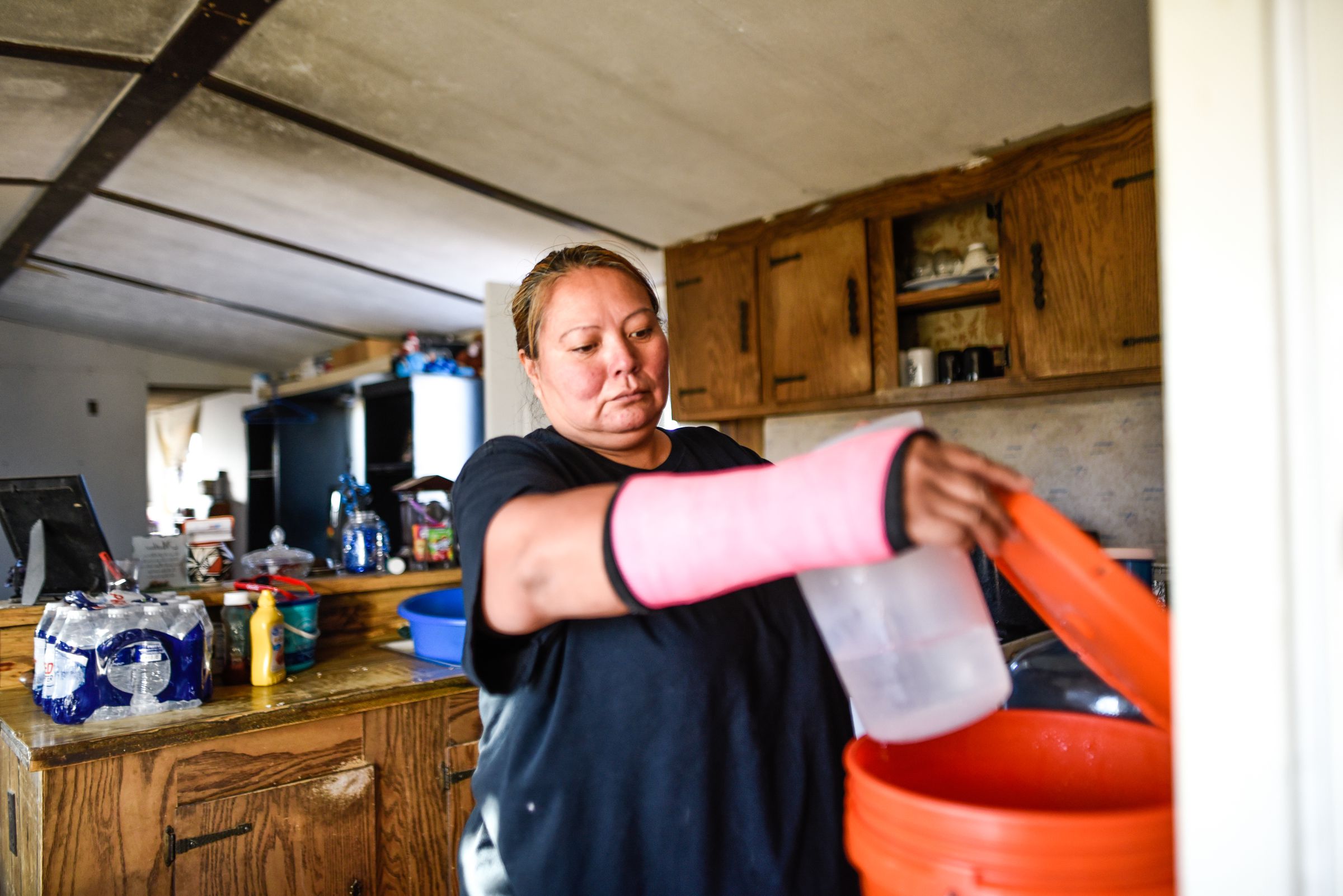 Rosanda Hudson prepares water for cooking in her home on the Navajo Nation prior to the installation of a home water system in 2017.