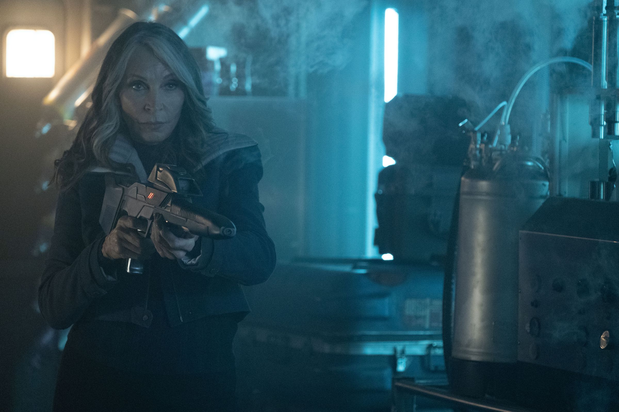 An older woman points a phase rifle at someone off-screen.