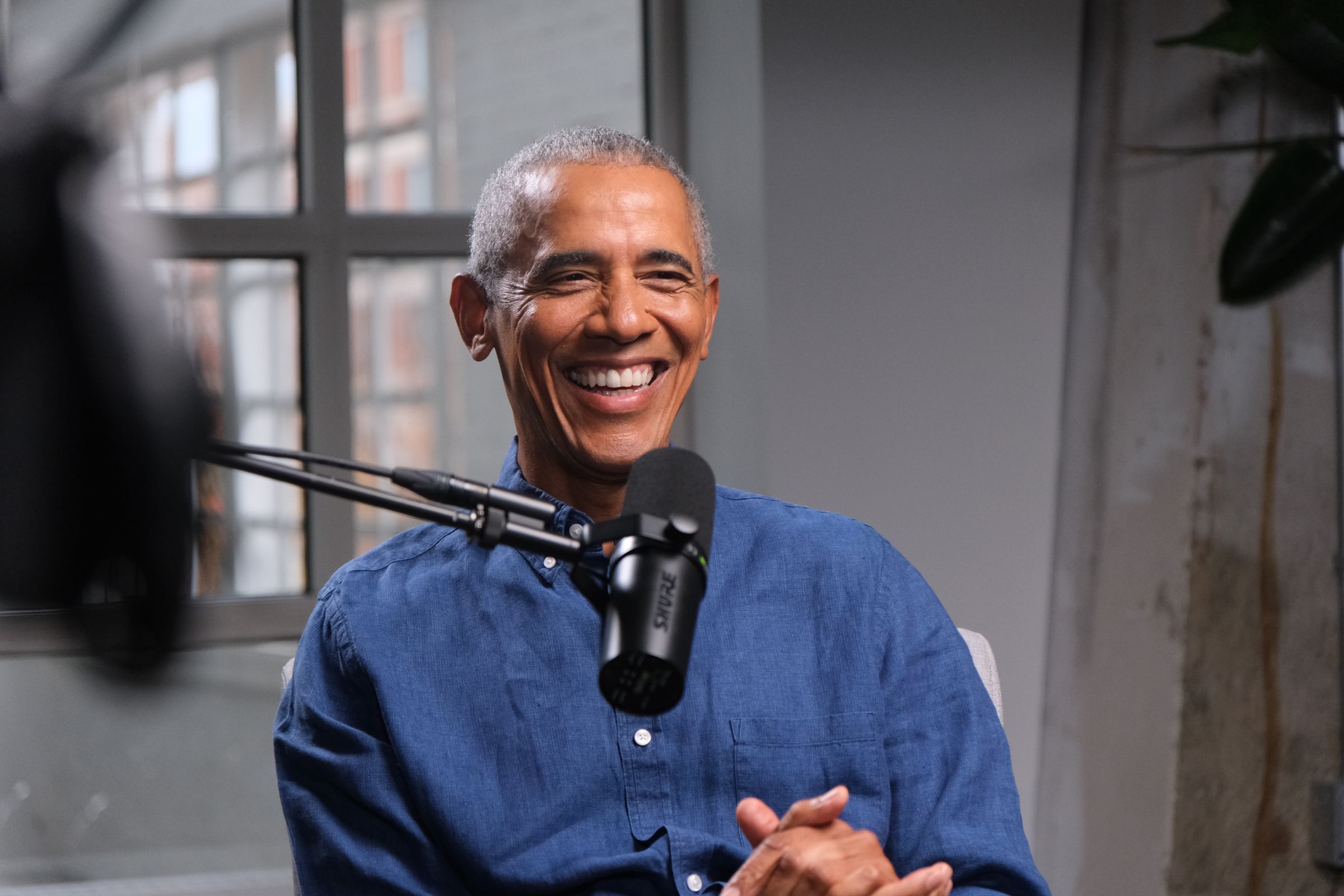 Barack Obama smiles while taping an episode of the Decoder podcast