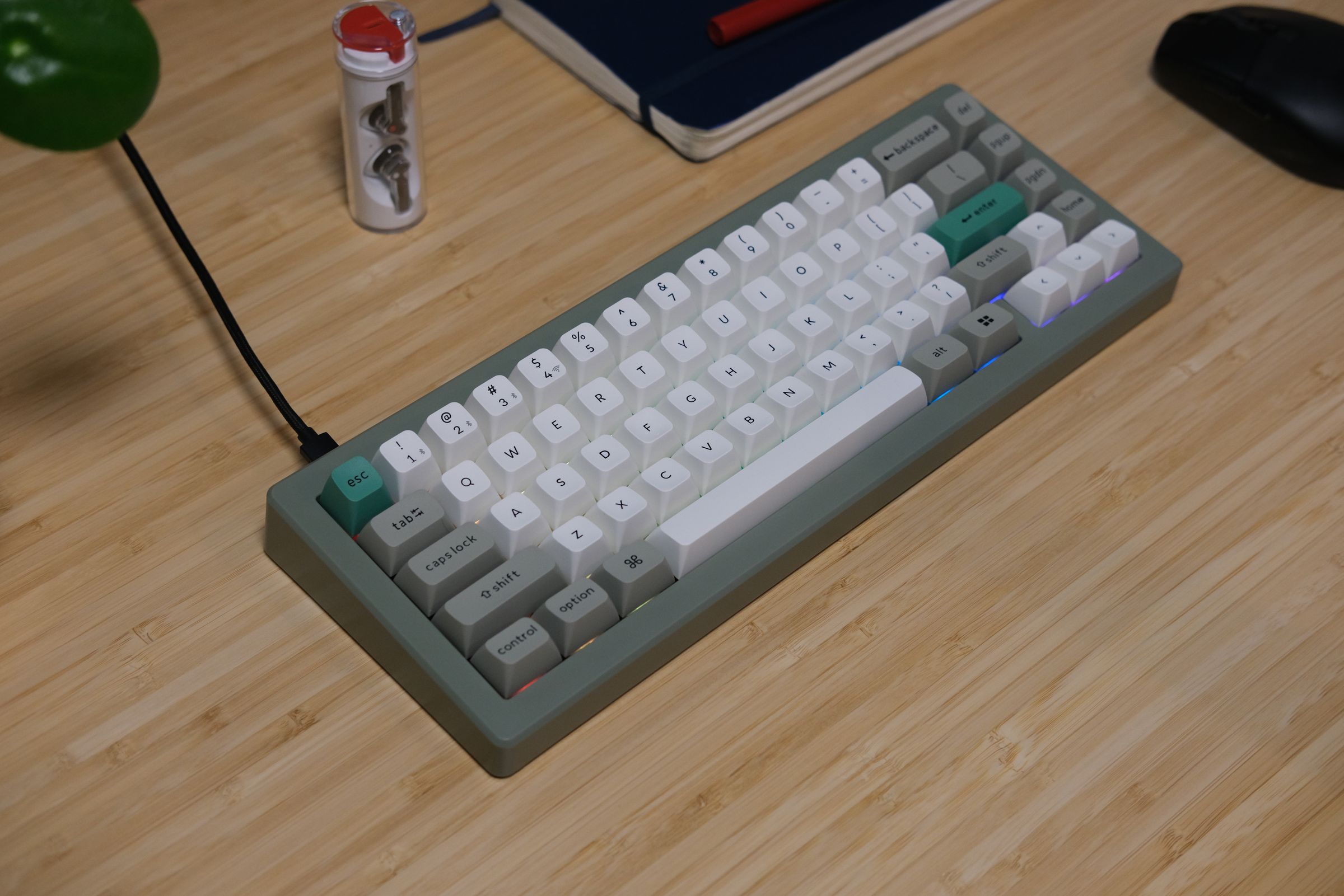 CSTM65 on a desk with white and green keycaps and a green case.