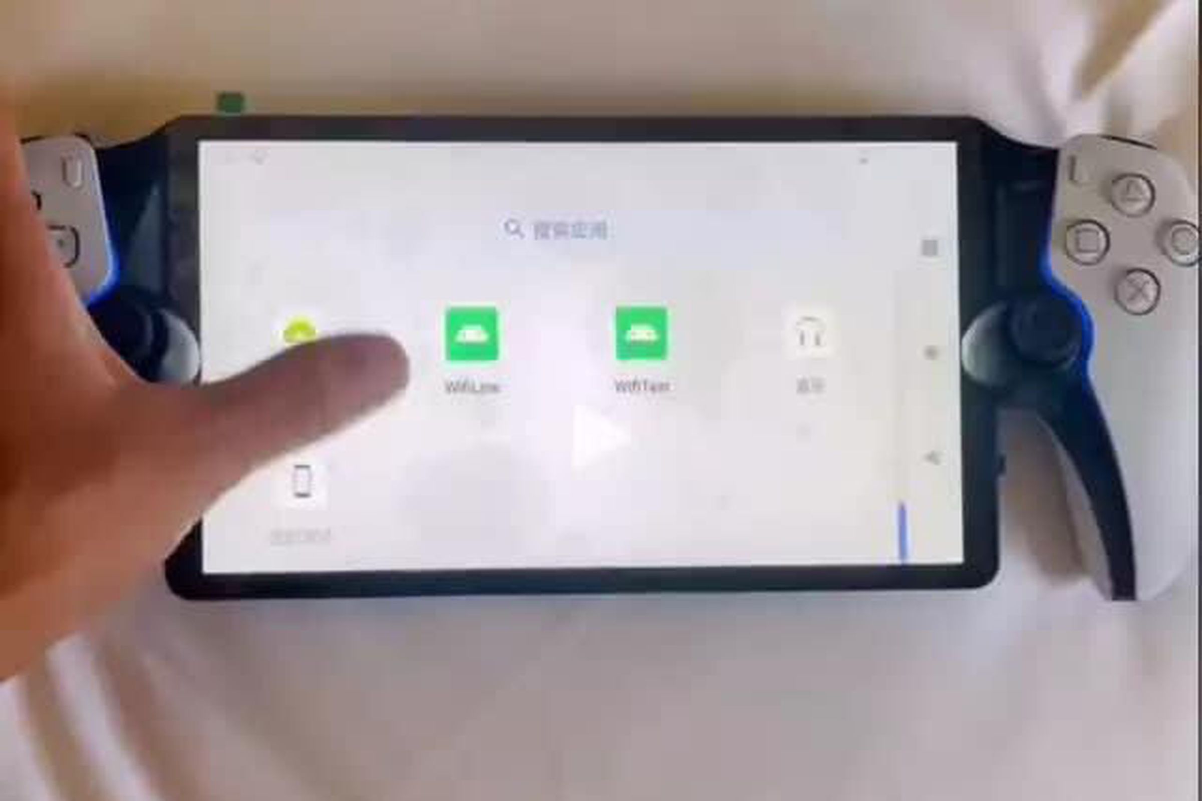A leaked image showing the PlayStation Q on a sheet, with a thumb tapping a menu option.