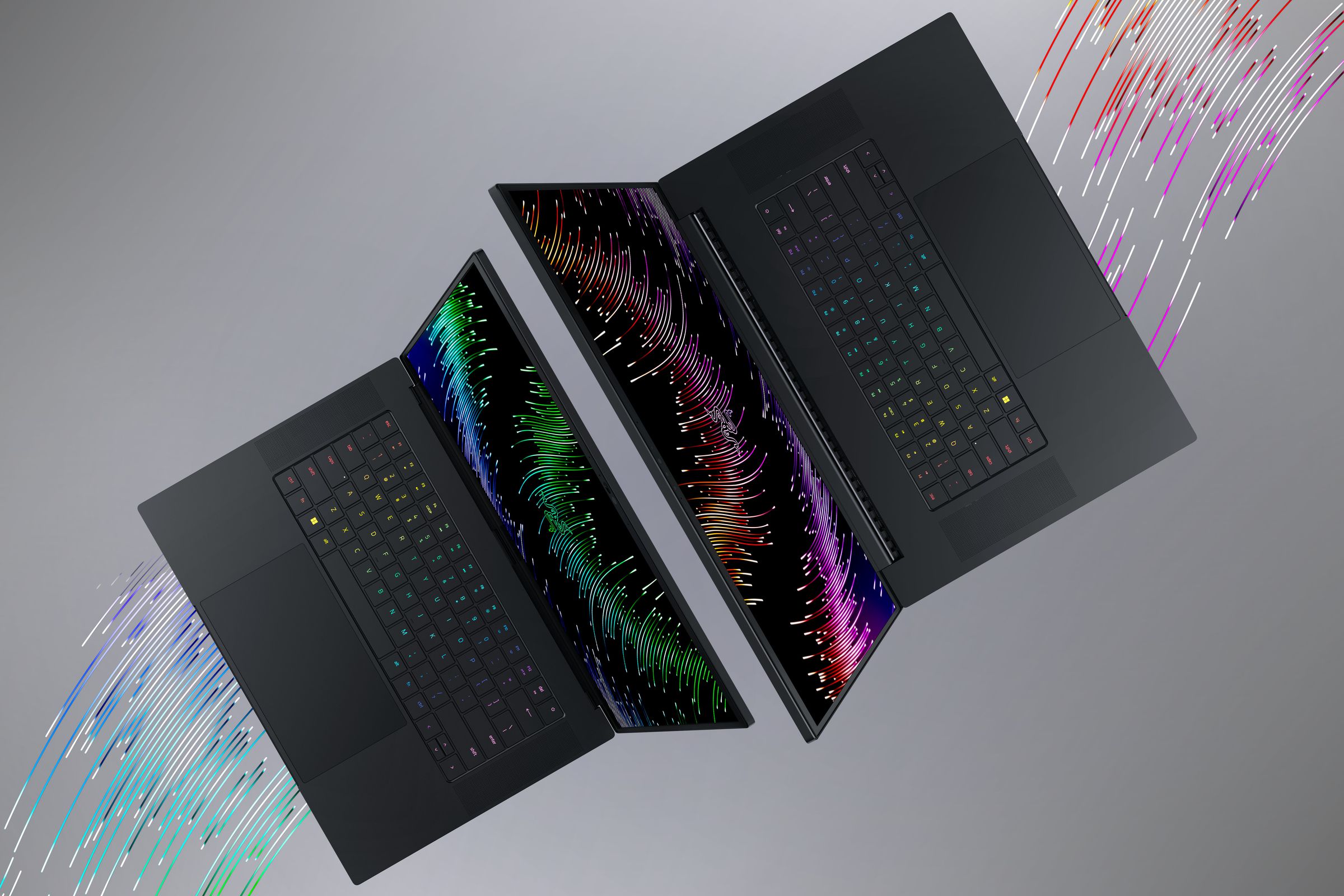 An artistic render of the Razer Blade 16 and 18 gaming laptops shows from the top-down, revealing their displays, keyboards, and trackpads.