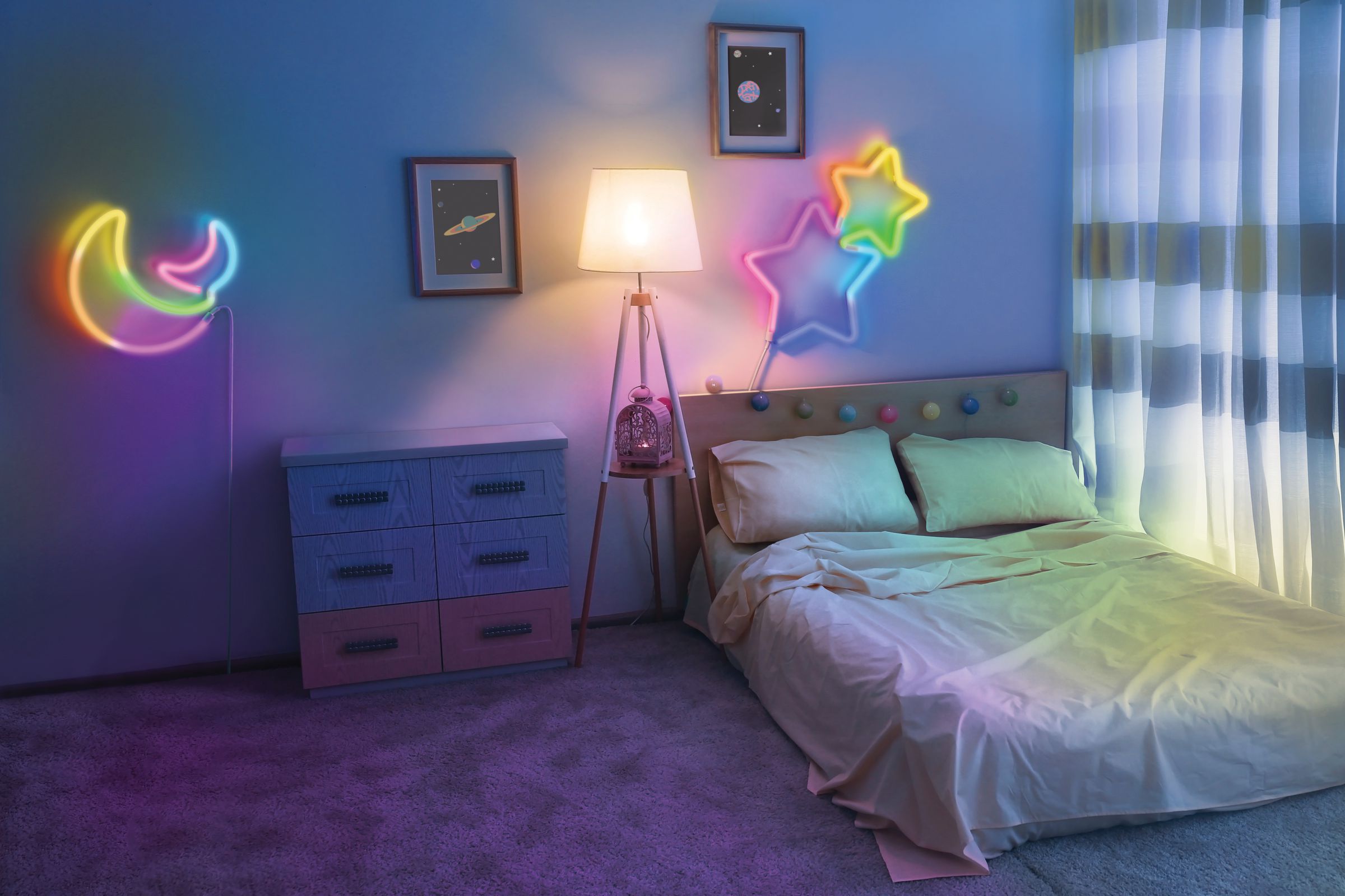 A bedroom with neon lights shaped like a moon and star on the wall.