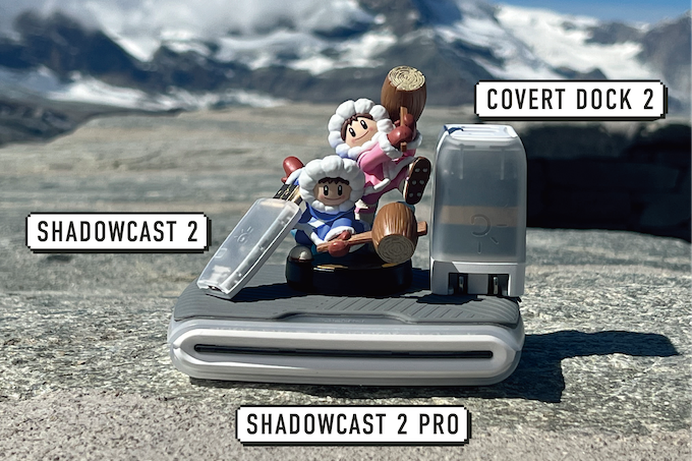 Ice climber amiibo with ShadowCast 2 dongle and Covert Dock 2 power adapter in translucent plastic, plus the ShadowCast 2 pro slab.