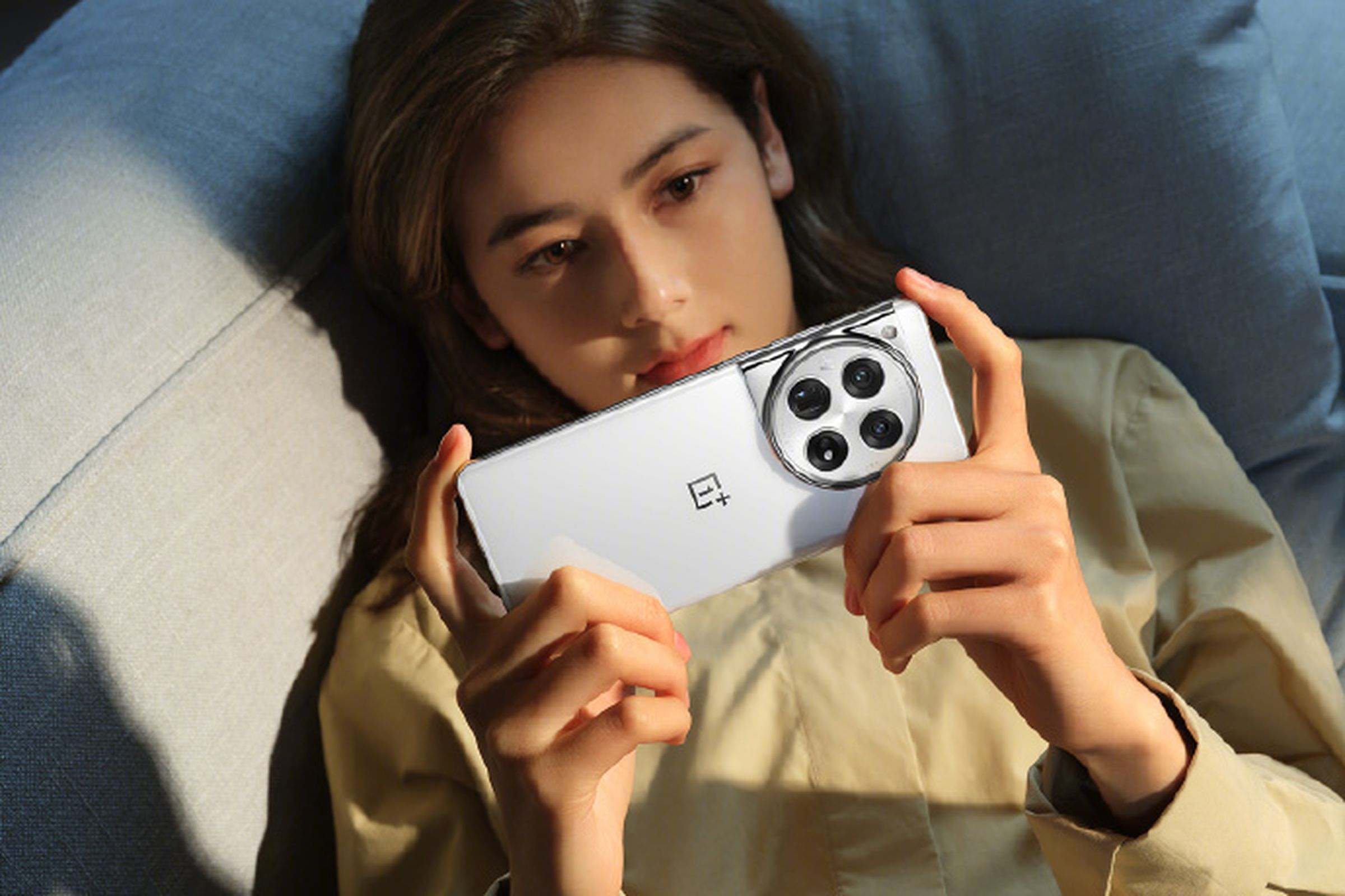 A woman holding the OnePlus 12 phone in white.