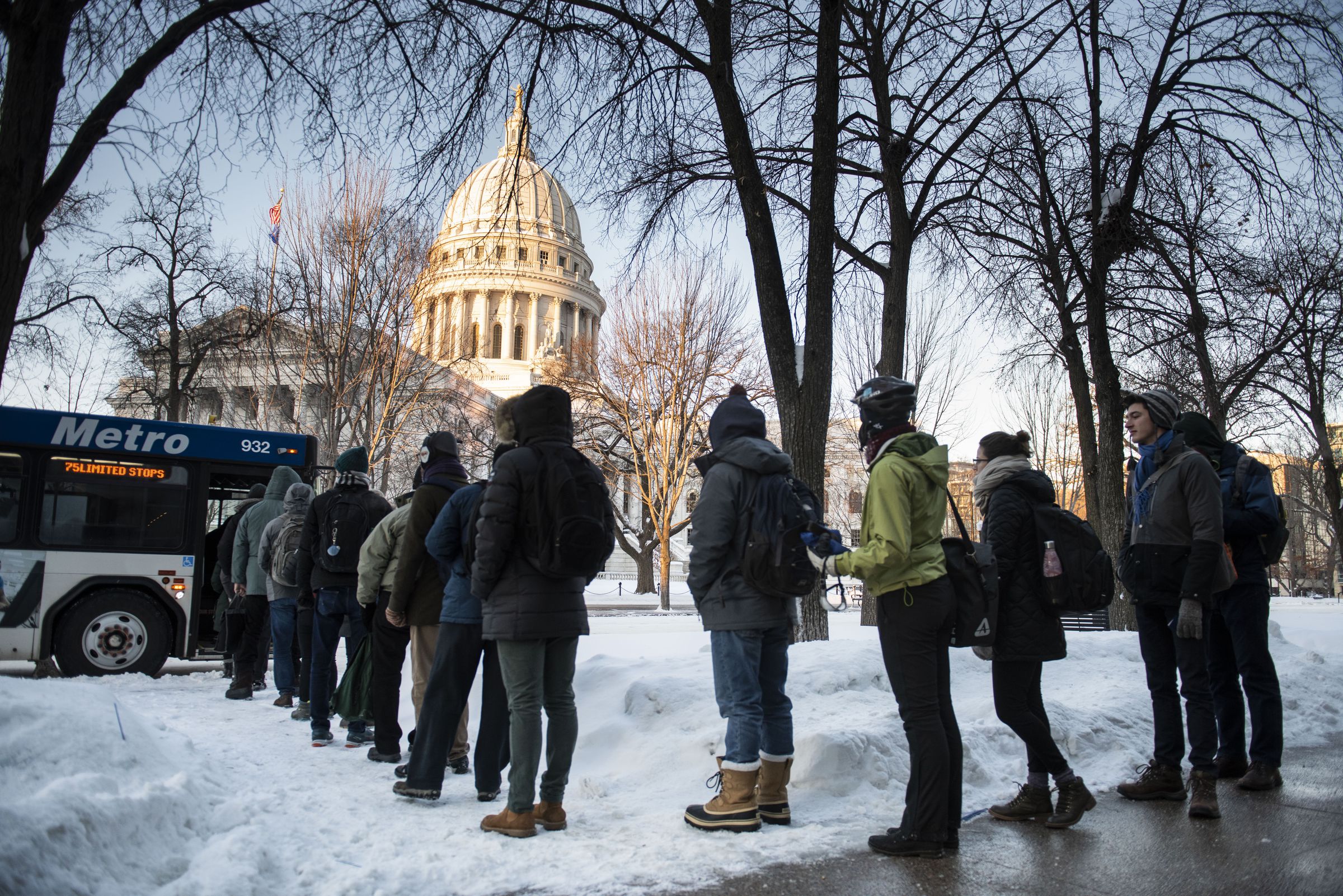 Commuters wait for the bus on South Pinckney Street in downtown Madison, Wisconsin, as extreme temperatures hit the region.
