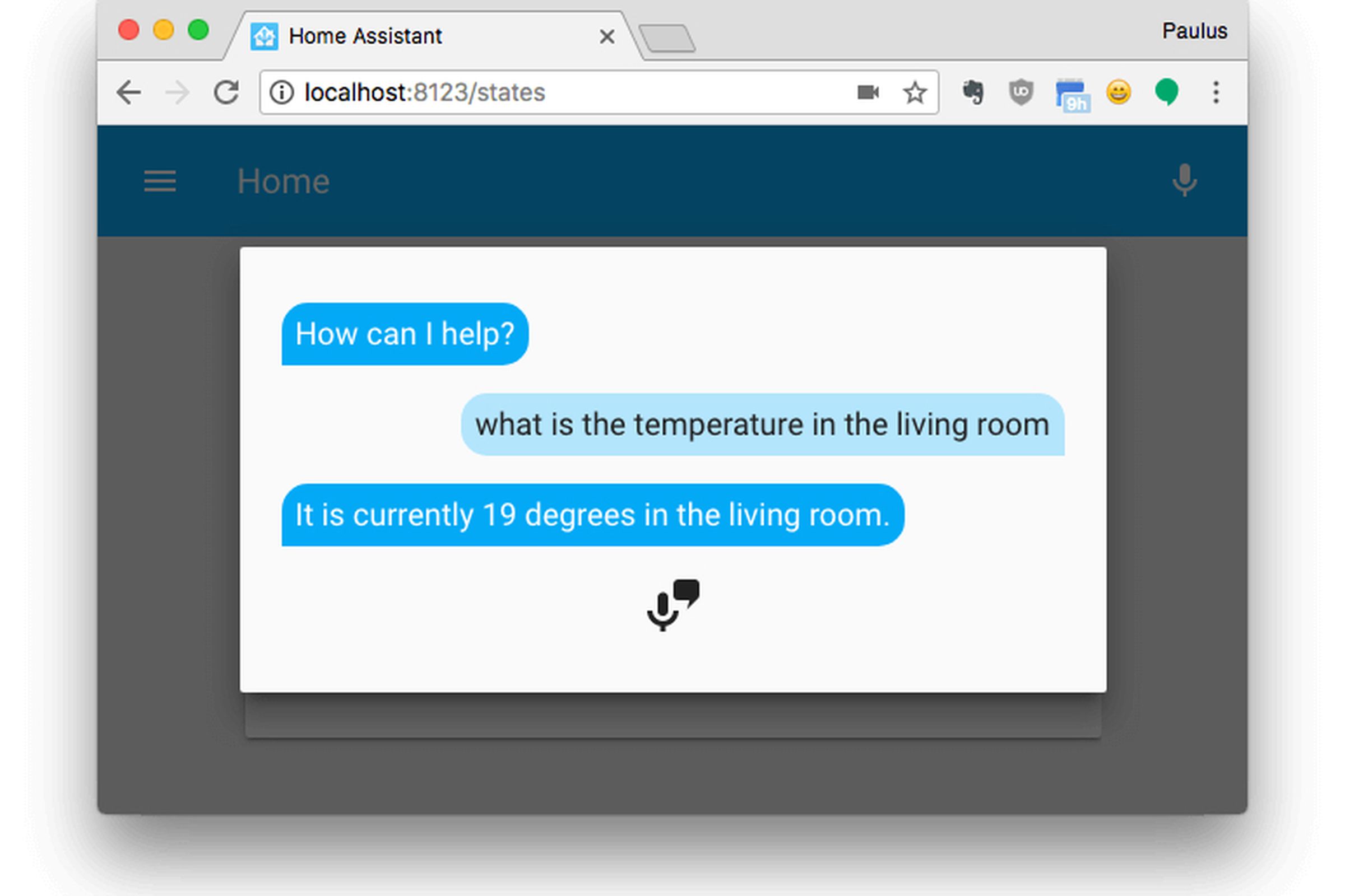 The home assistant application is running in a browser window, and a microphone icon is at the bottom of a smartphone style text message conversation between a bot and a user asking what temperature it is in the living room.