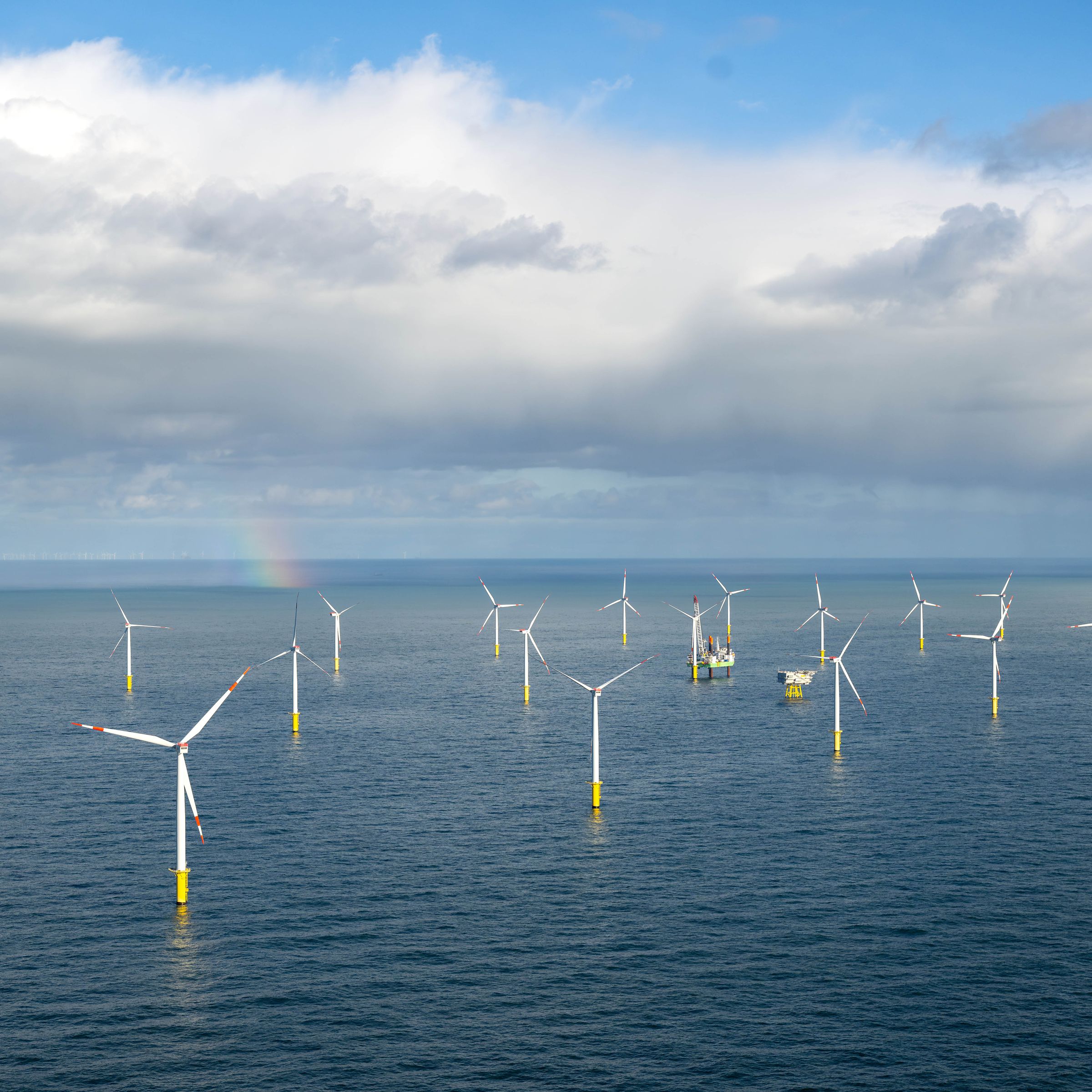 Several rows of wind turbines standing in the sea.
