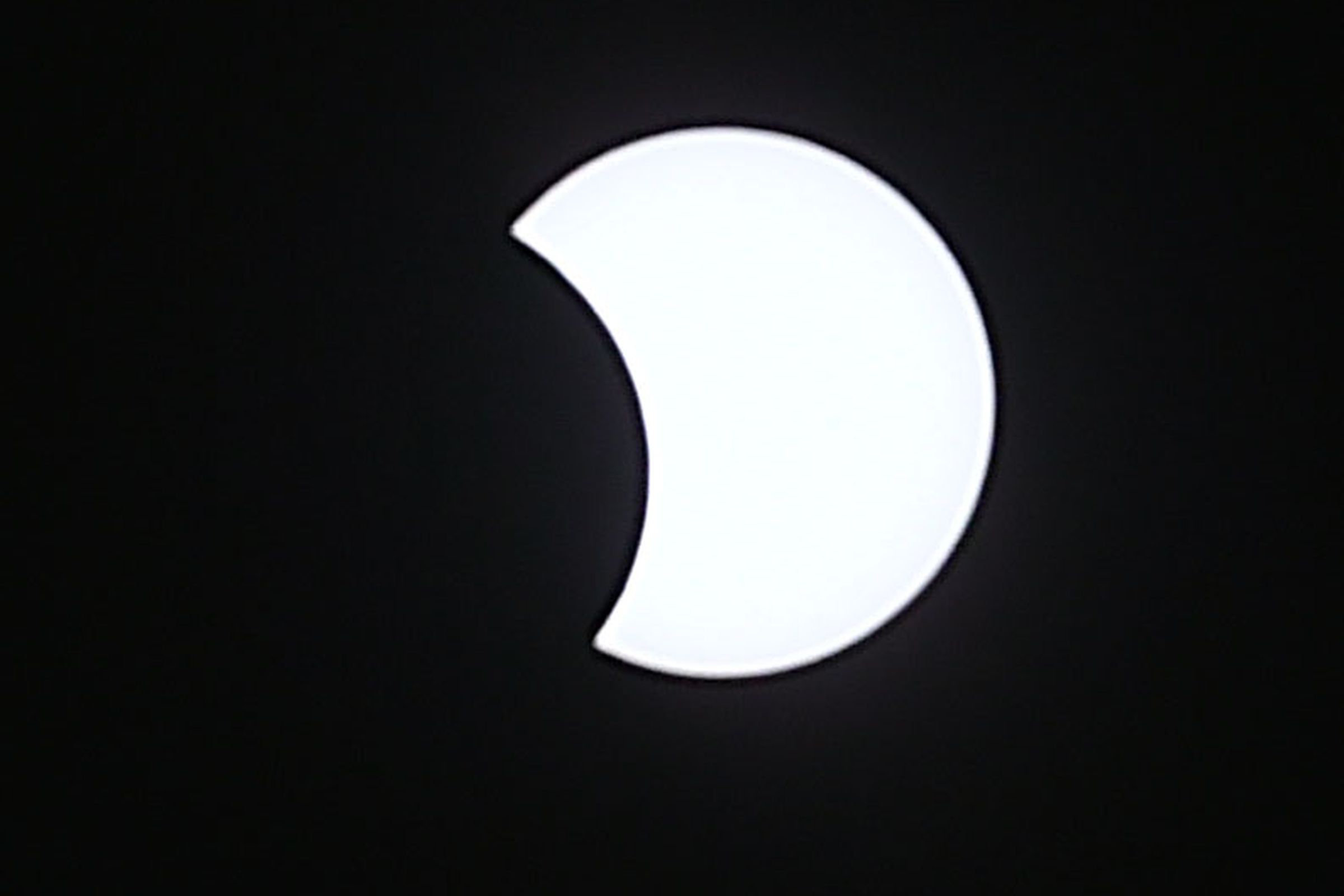A view of a crescent sun partially blocked by the moon.