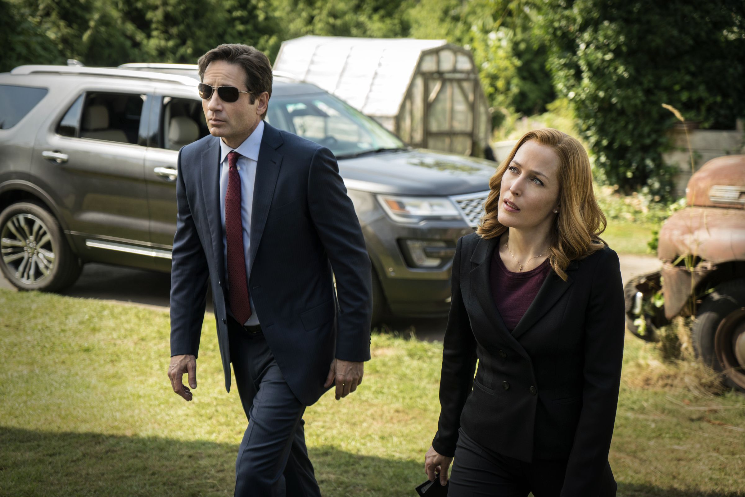 An image of David Duchovny and Gillian Anderson as their characters, Mulder and Scully. Both are wearing little business suits.
