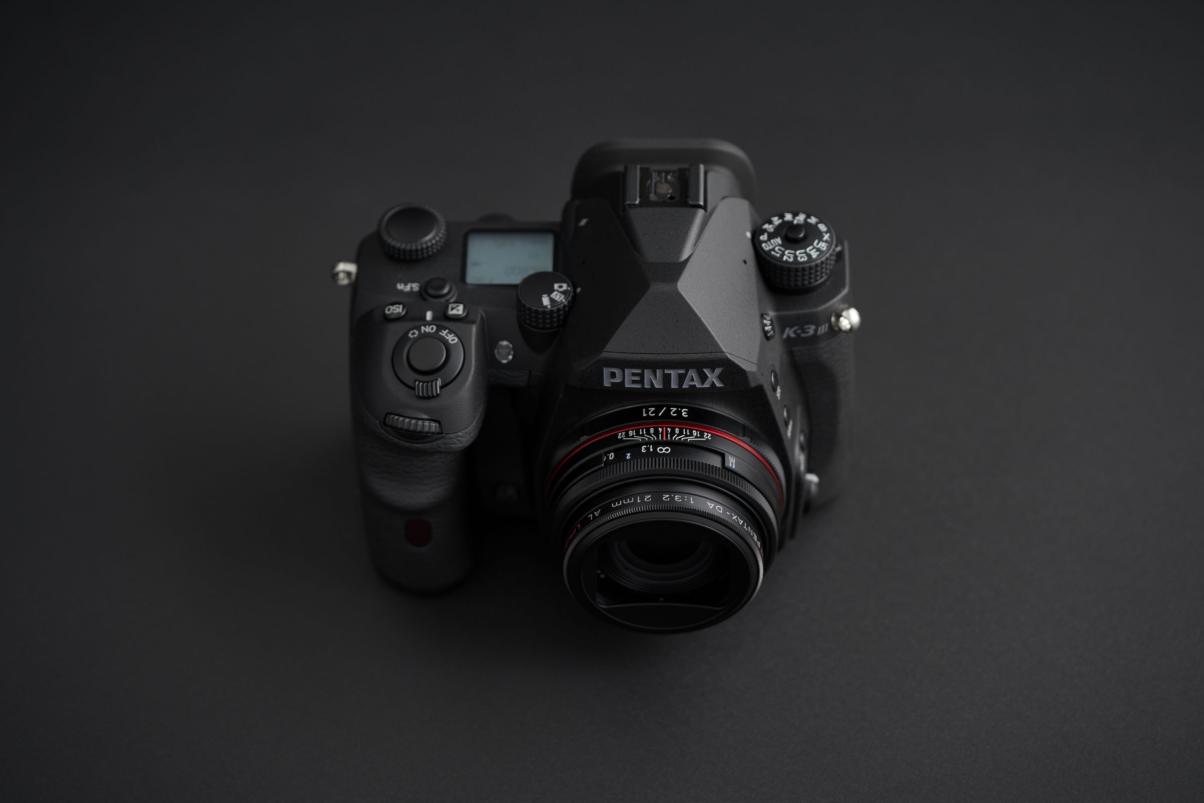 A Pentax K-3 Mark III Monochrome camera on a gray background.