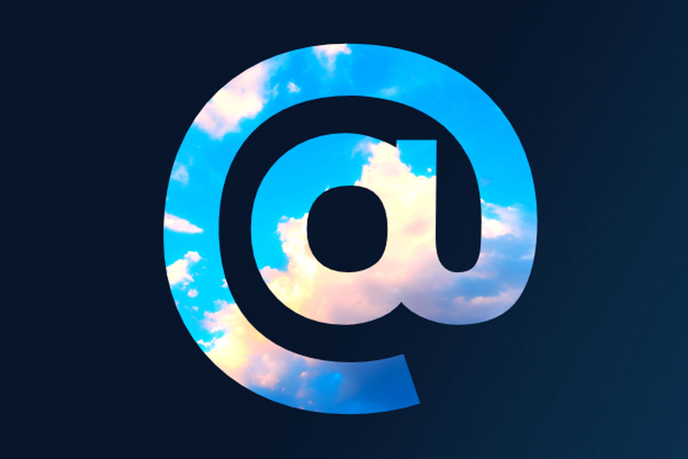An @ symbol showing a window to a bright blue sky with fluffy clouds.