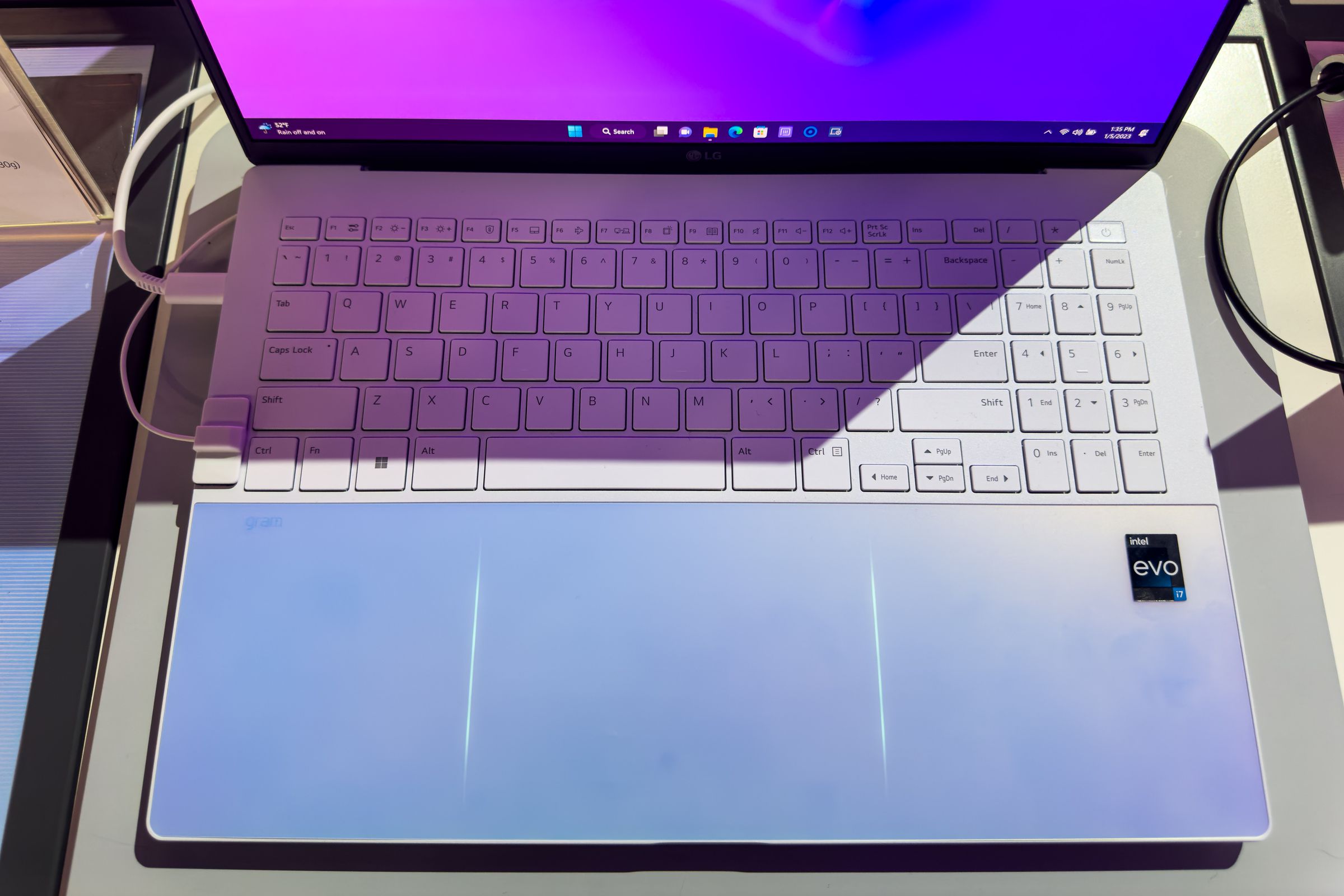 The LG Gram Style keyboard is seen from above with the touchpad LEDs backlit.