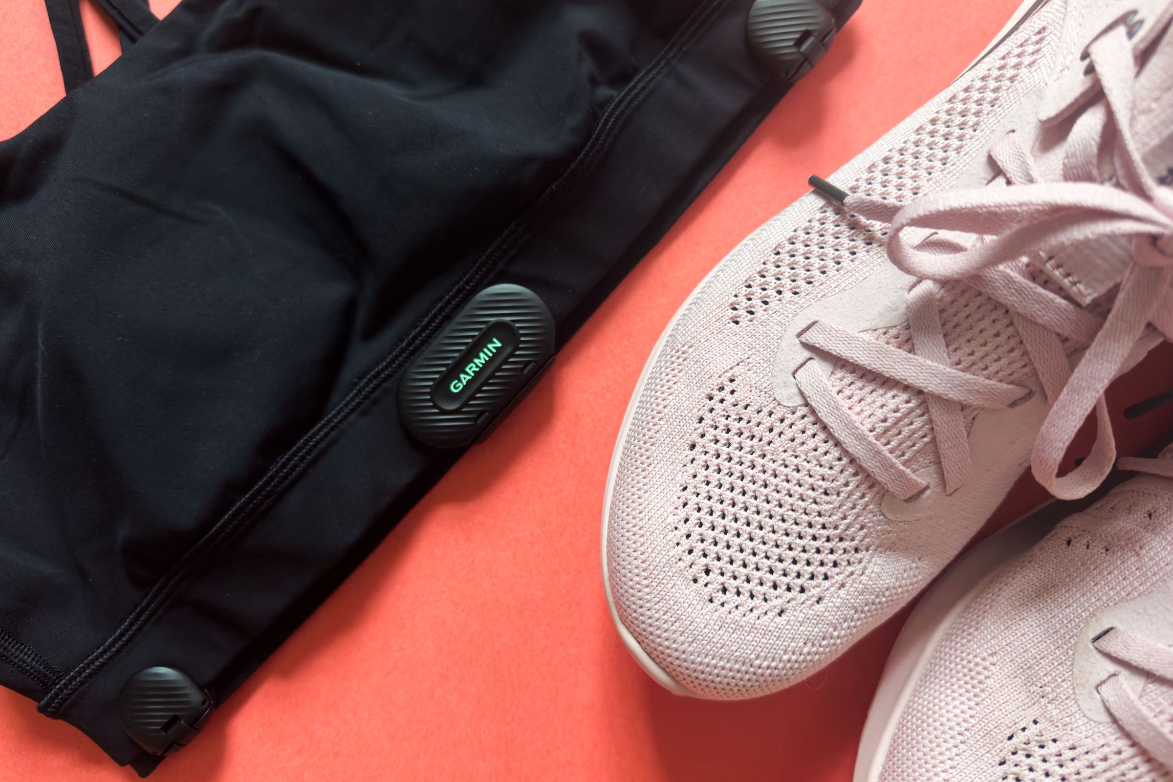 Garmin HRM-Fit on a sports bra next to some sneakers