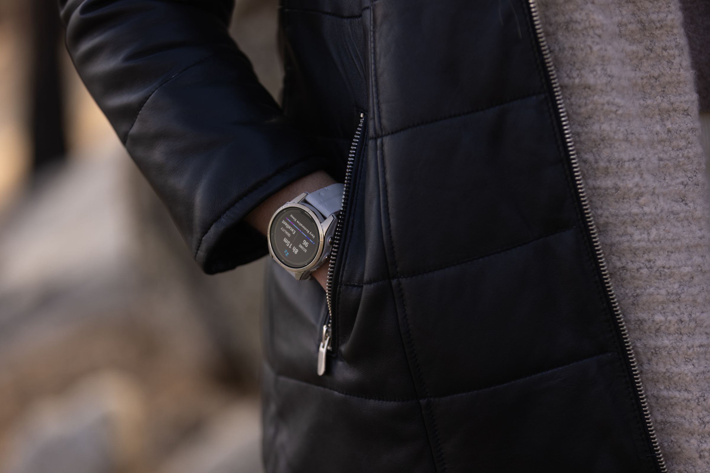 Close up of the Fenix 7 Pro worn on a wrist as someone puts their hand in a jacket pocket